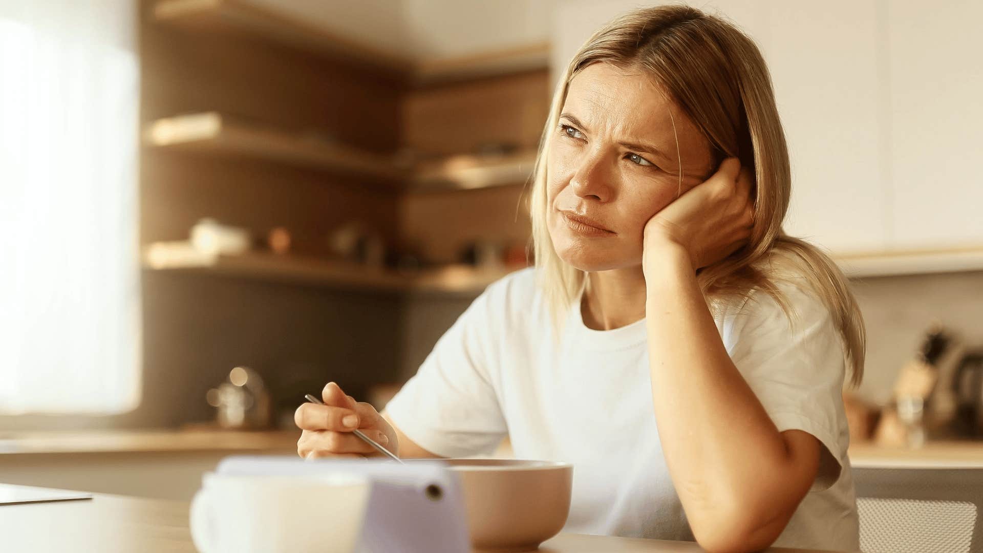 tired woman with incredibly low energy eating breakfast