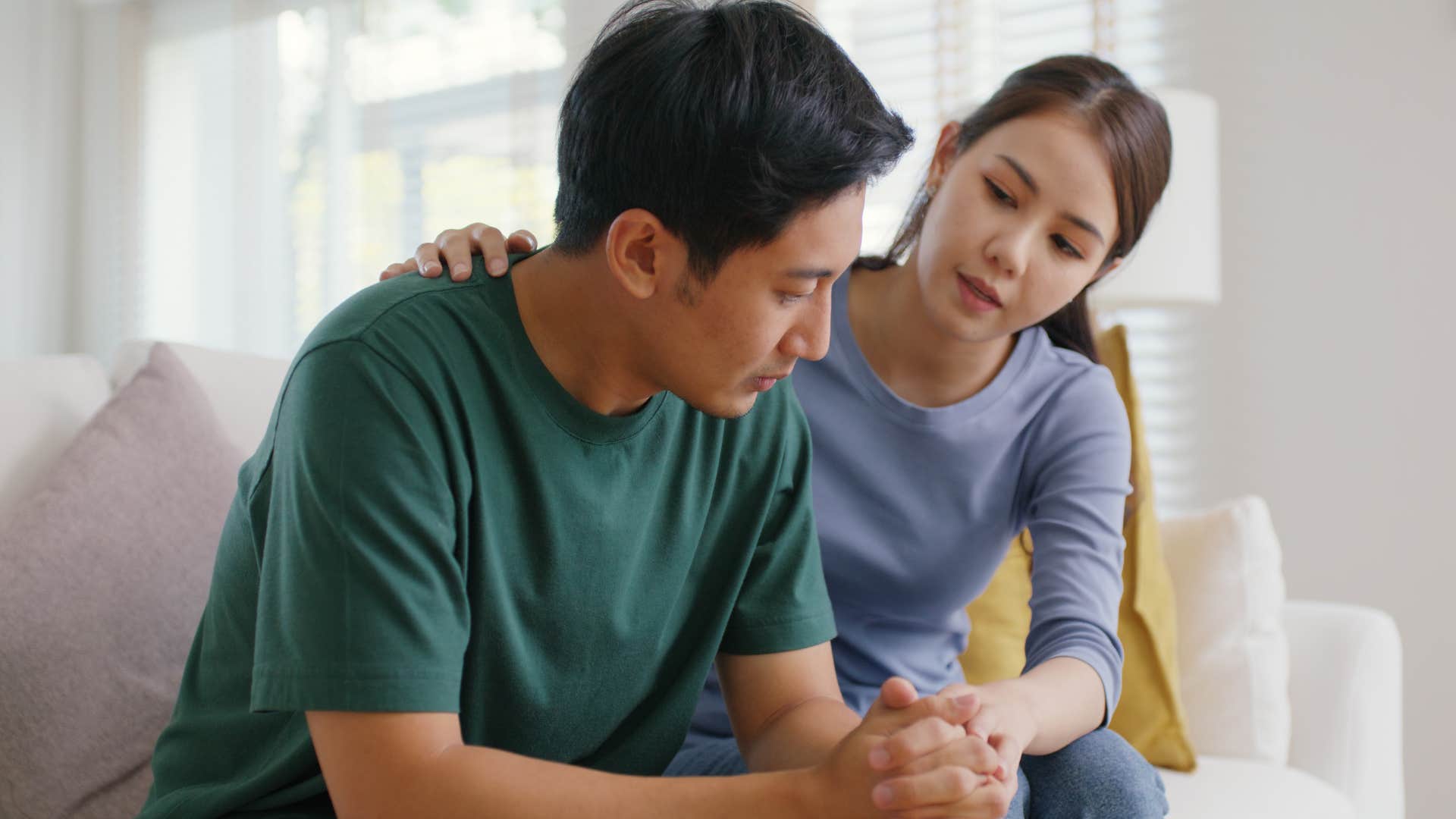 Man battling insecurities being comforting by his wife.