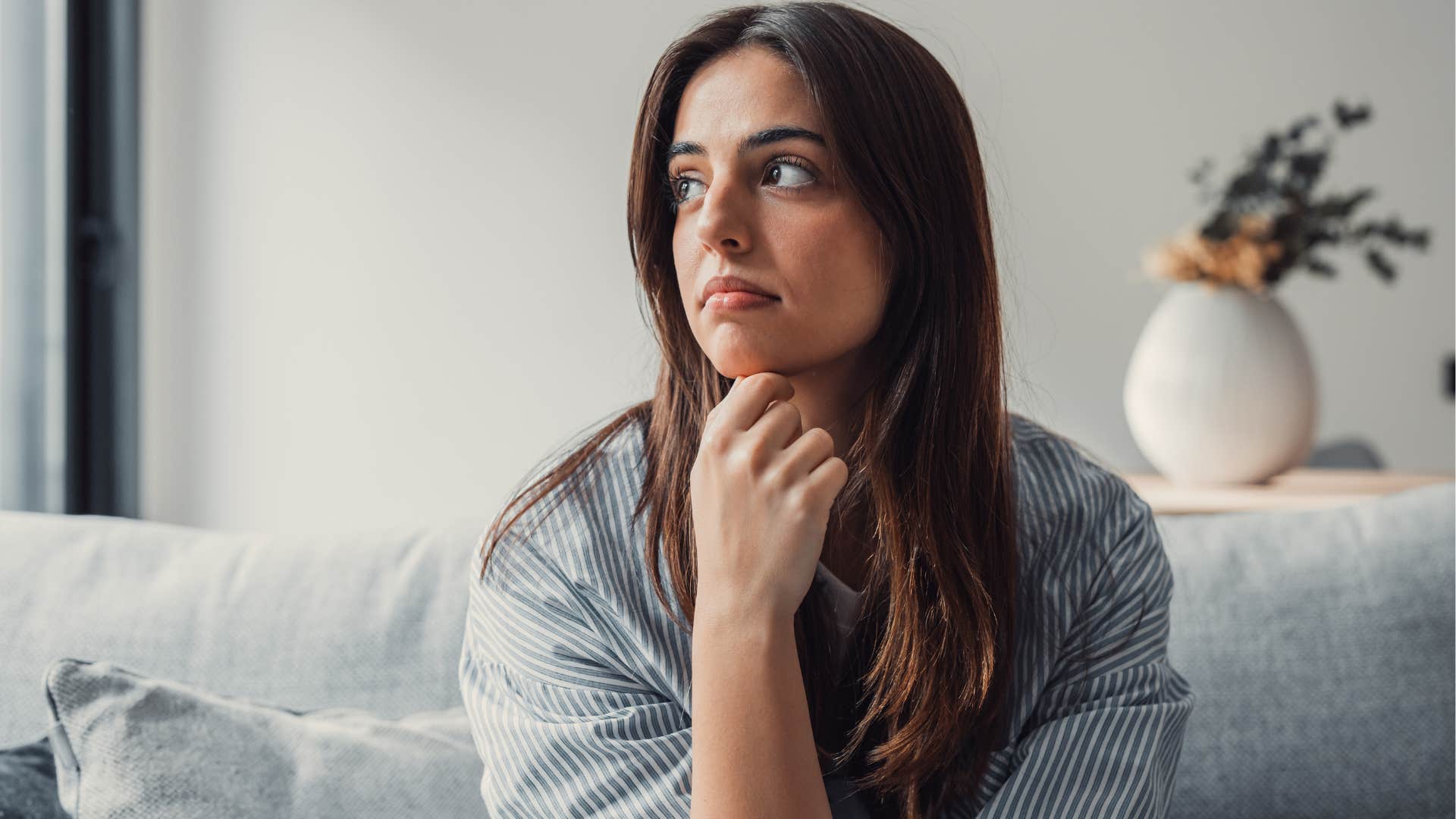 Woman with less opportunity to meet people looking out a window at home.
