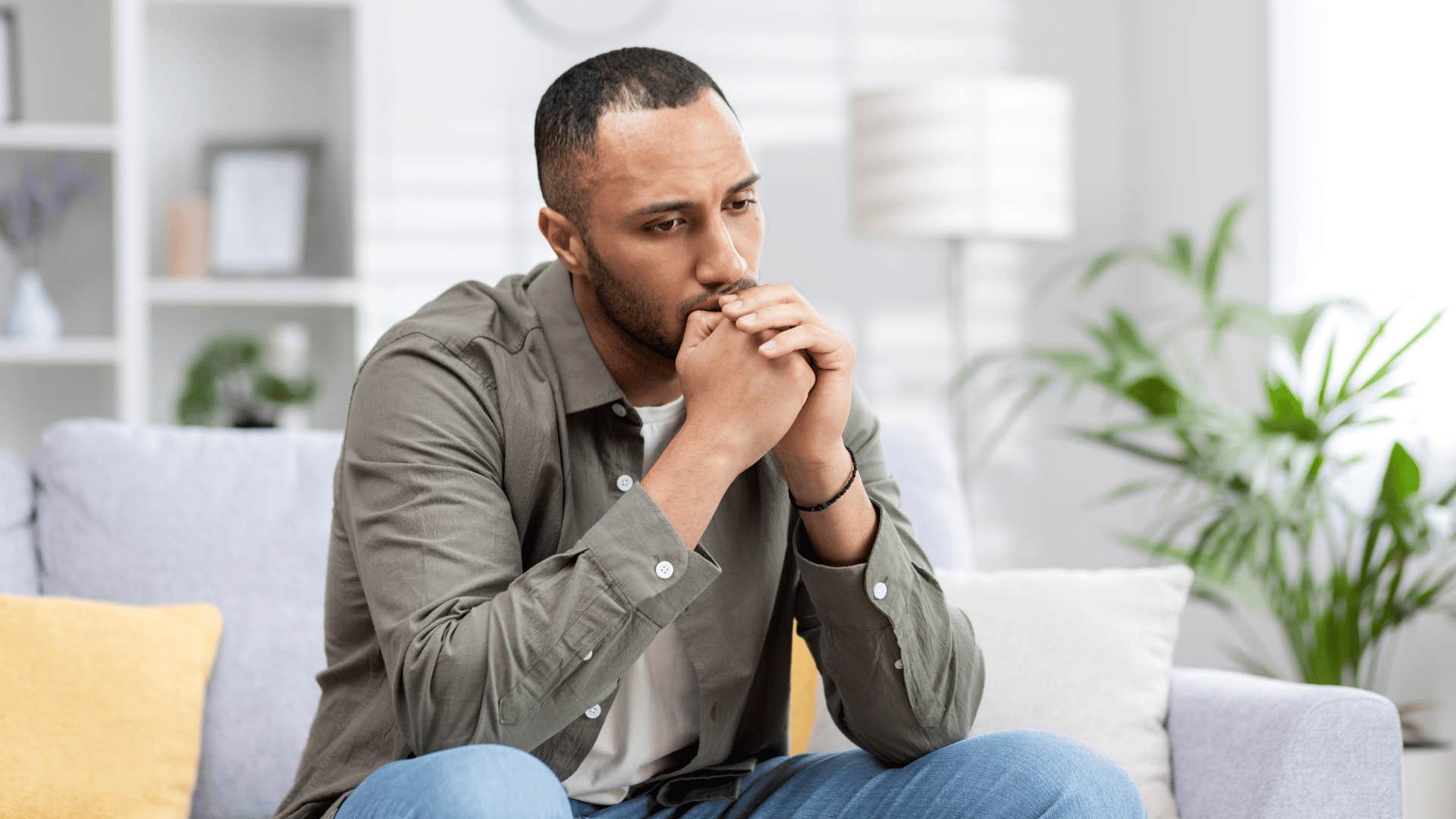 low energy man sitting on couch thinking about friendships