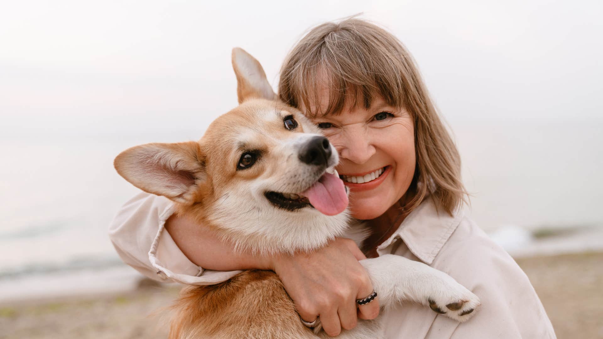 woman smiling with dog in arms