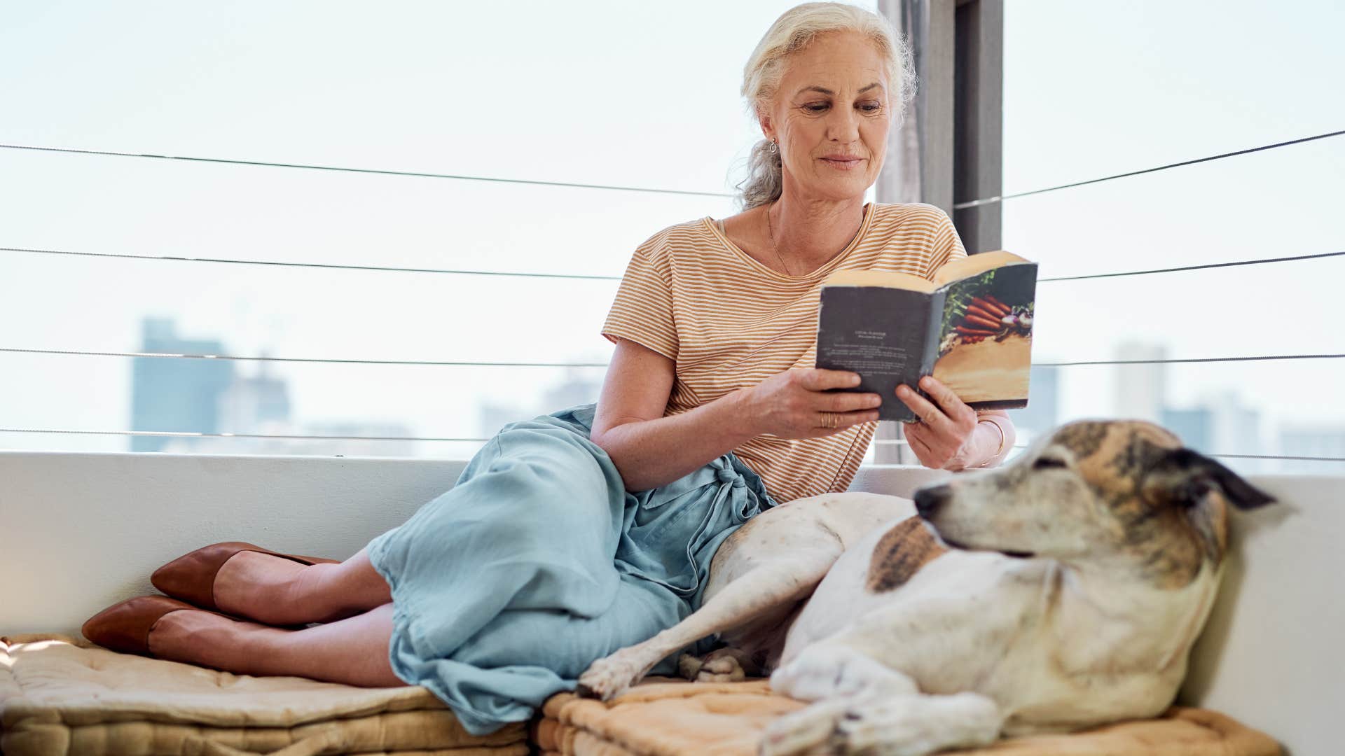 woman reading book next to dog not using energy