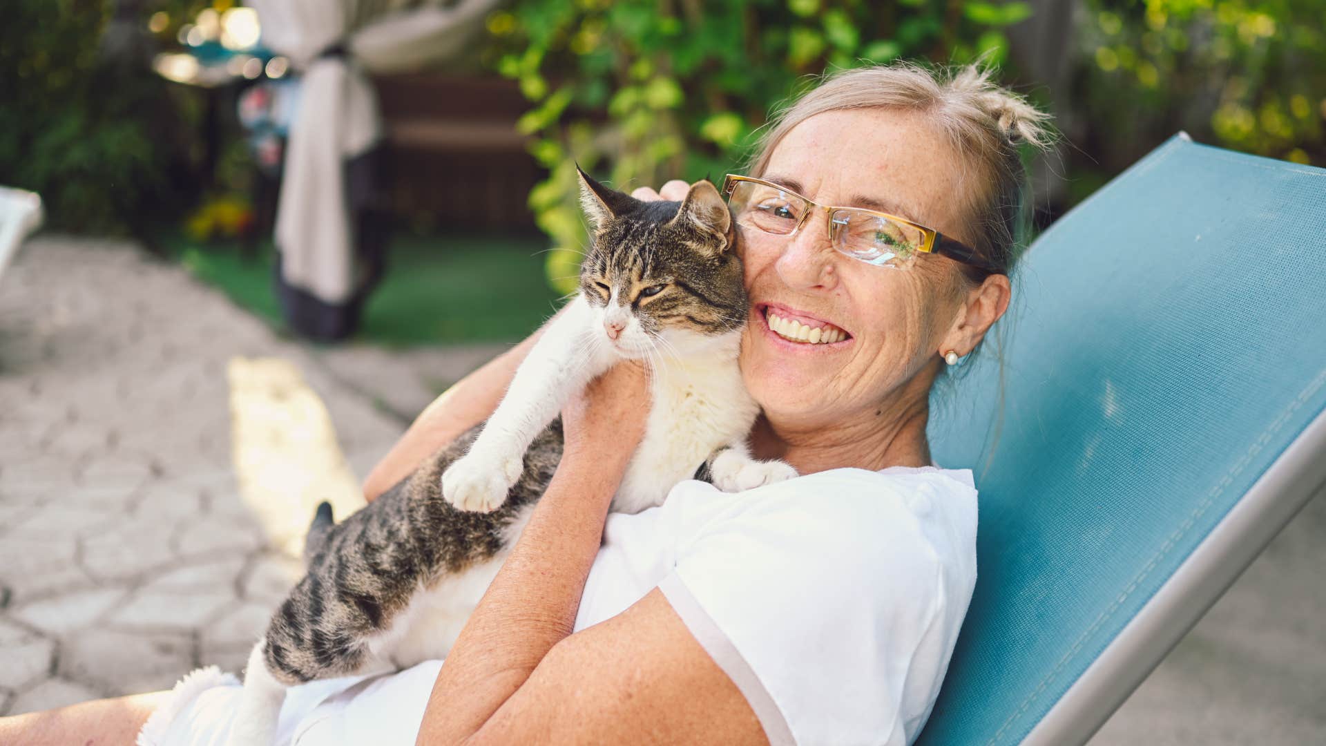 woman smiling not feeling lonely thanks to pet cat shes holding