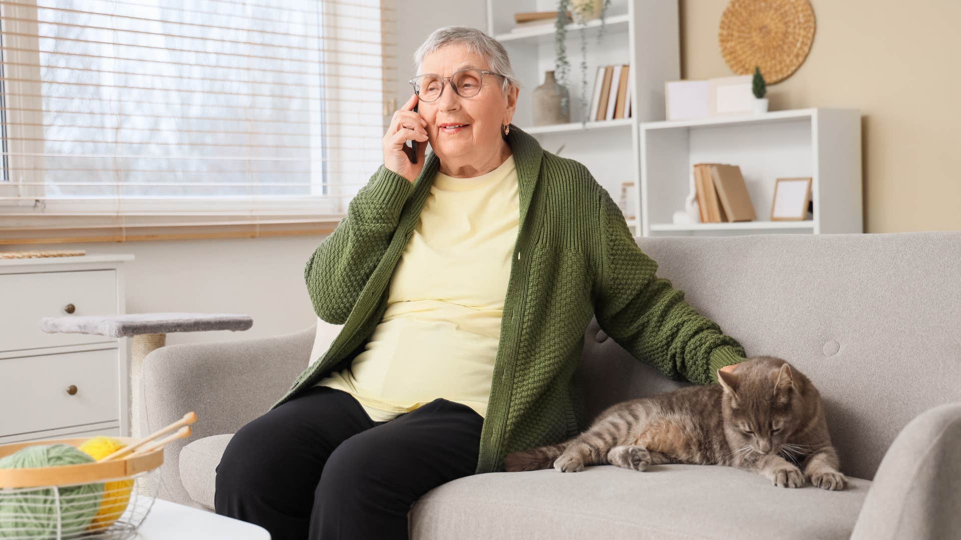 woman talking on phone and petting her cat