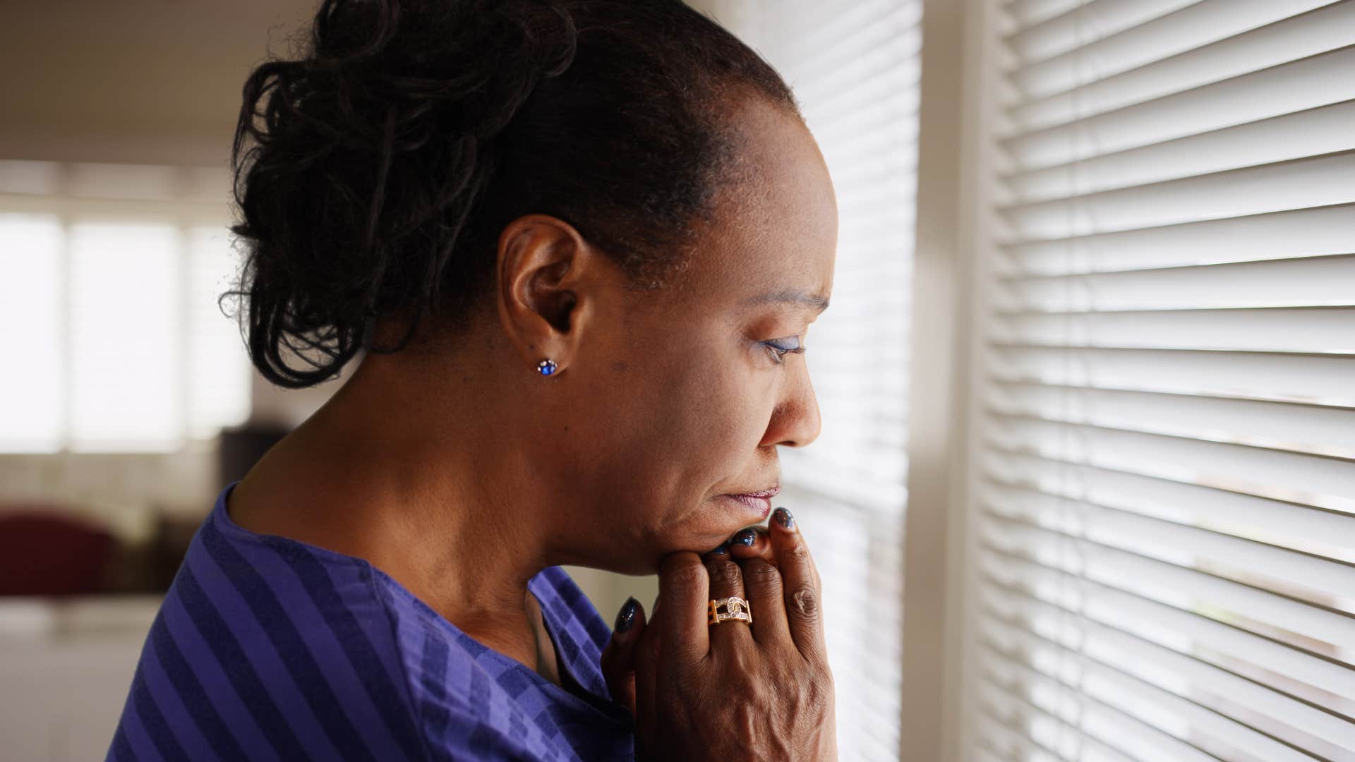 depressed woman looking out her window