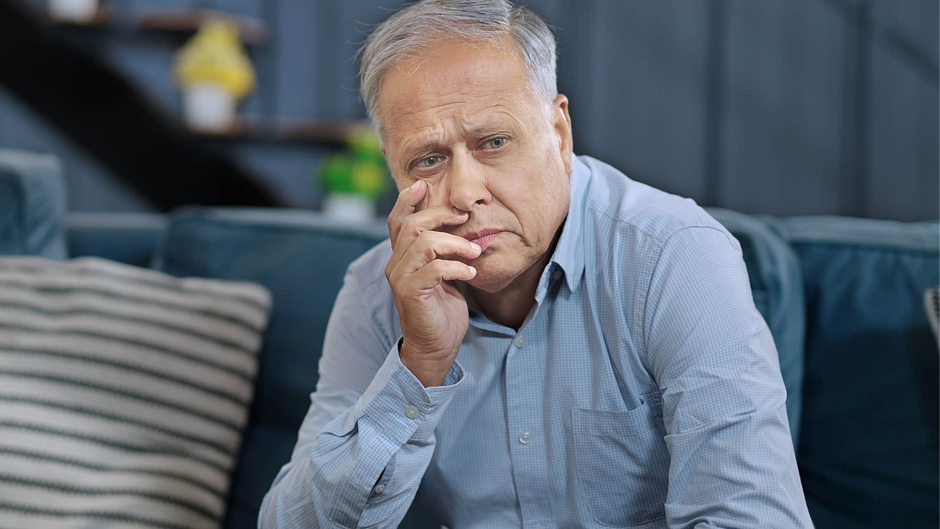 independent man sitting with his face in his hands