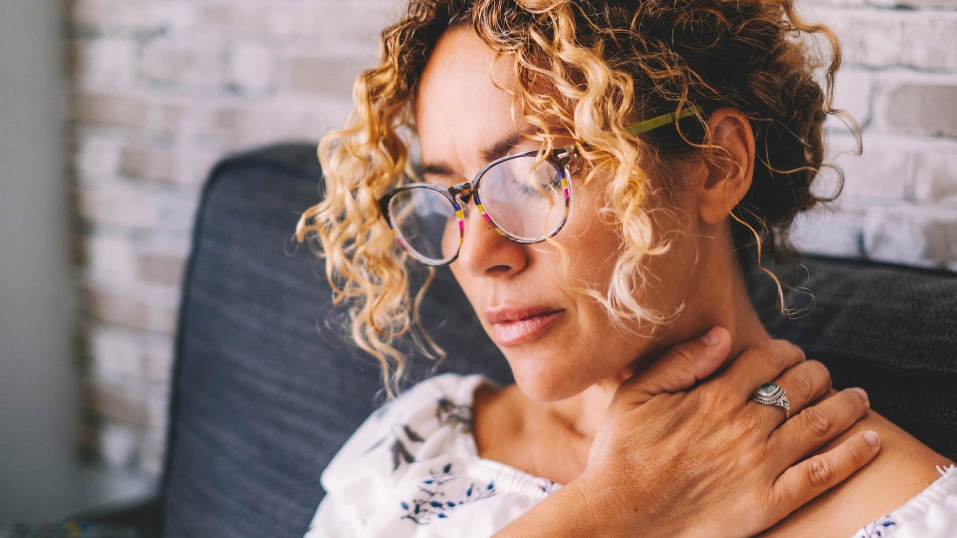 woman with a chronic condition holding her neck in pain