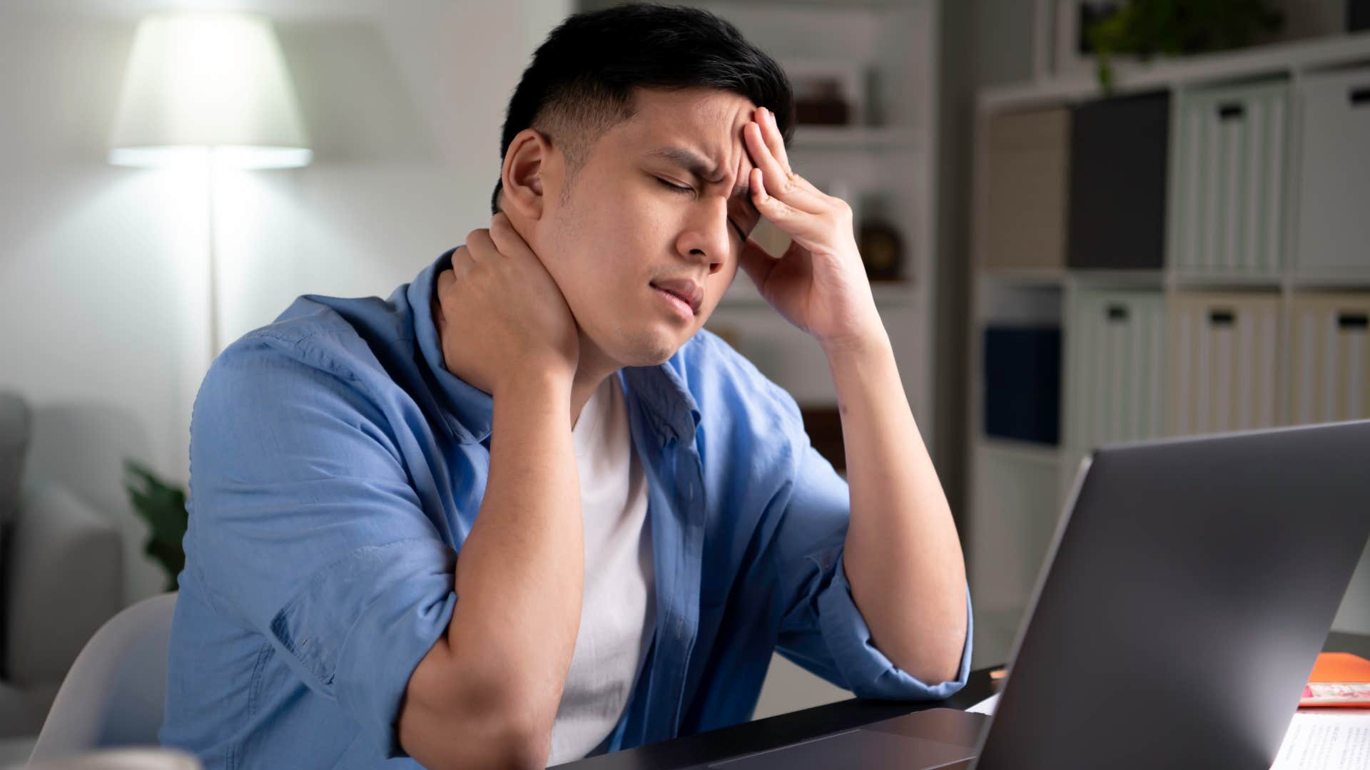 Man with a weakened immune system holding his head.