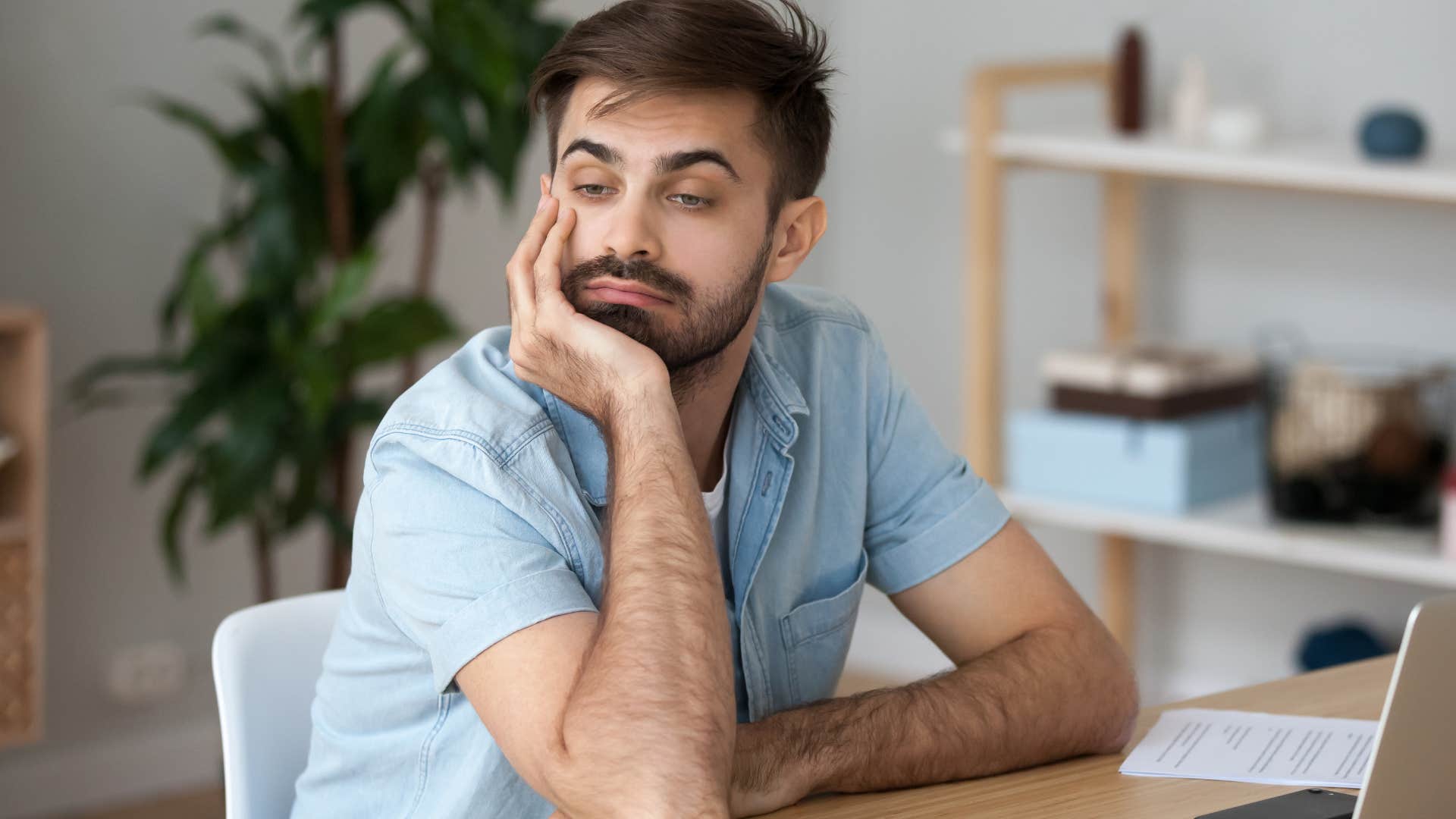 Man who's less productive during the day looking bored at his desk.