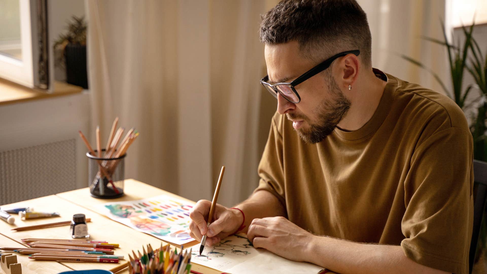 Man working with art supplies in his house.