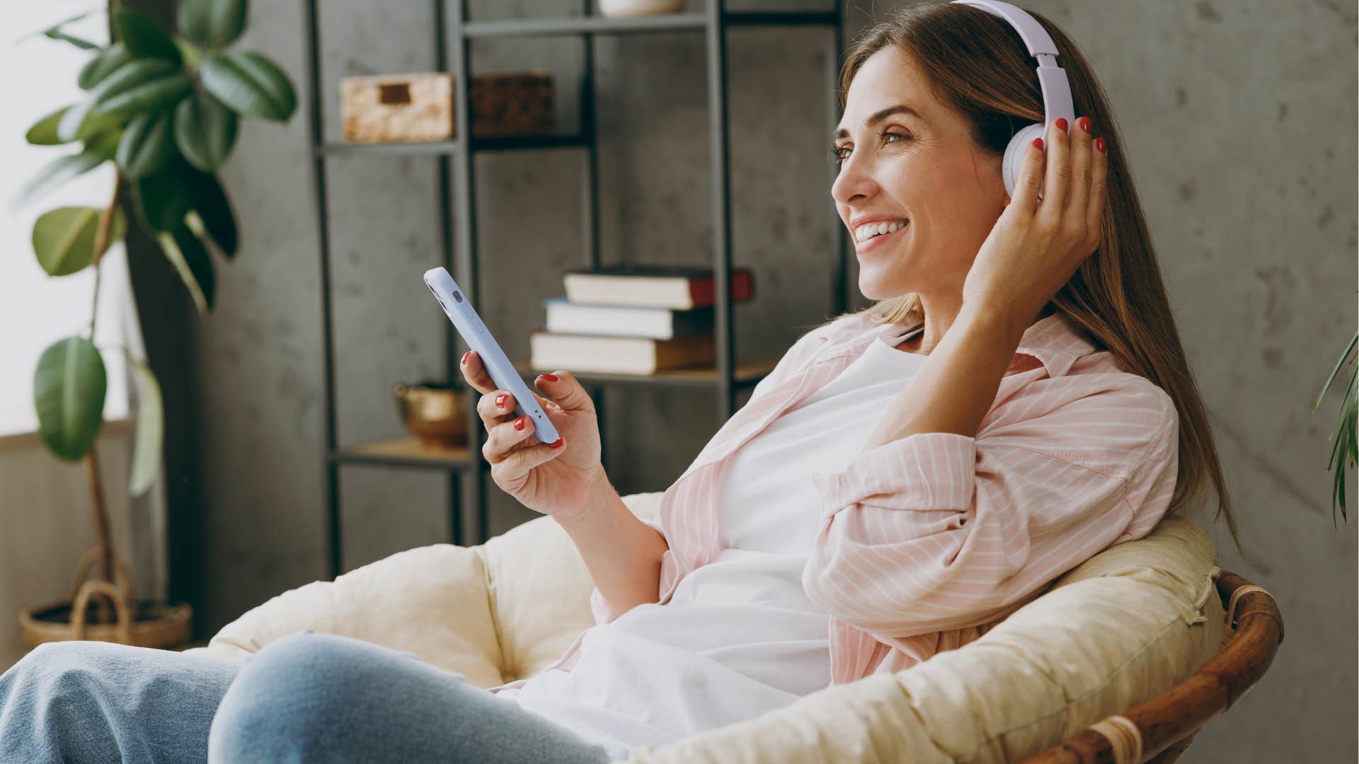 Woman sitting on comfortable furniture and listing to music.