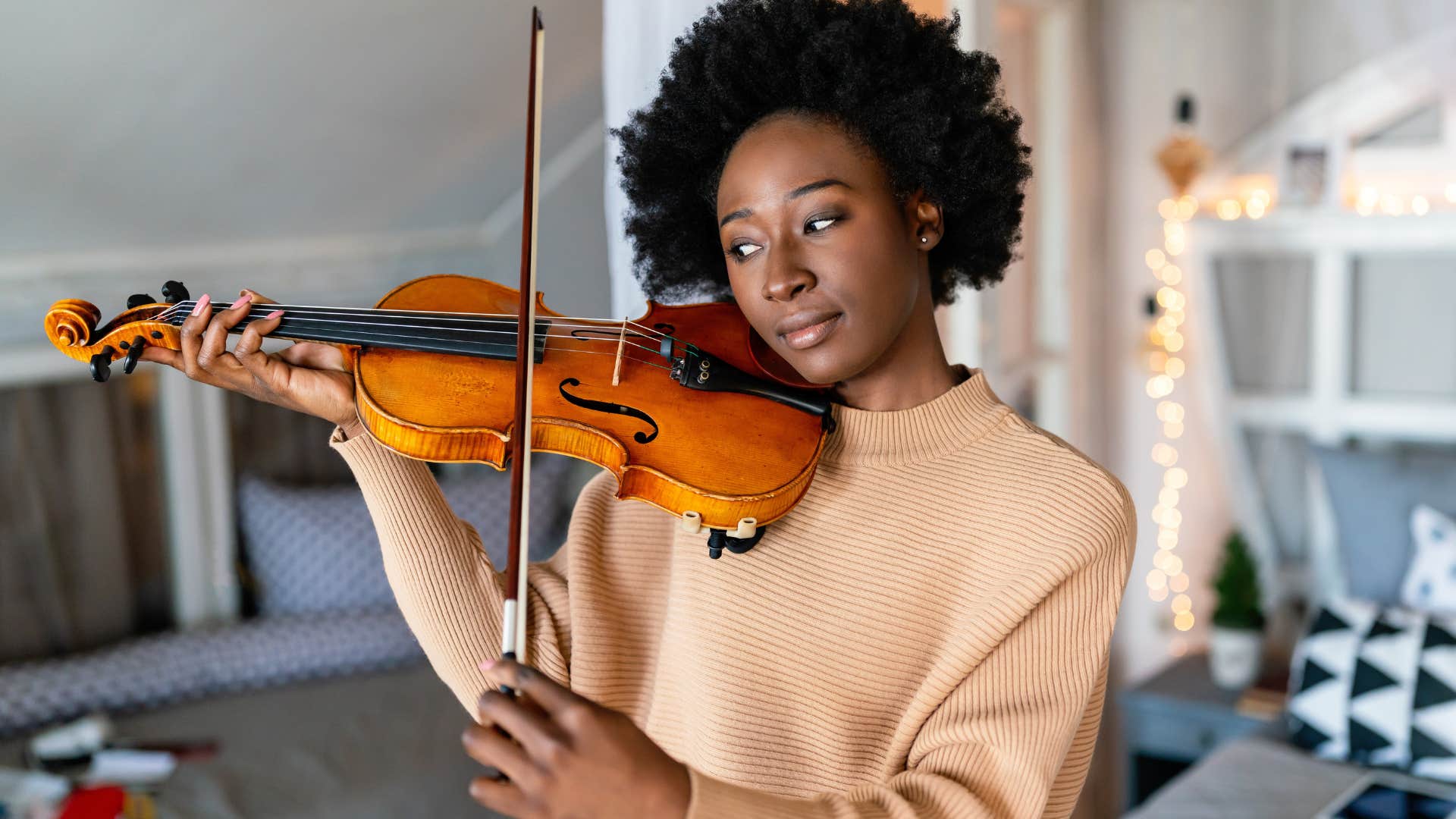 Woman playing a musical instrument in her house.