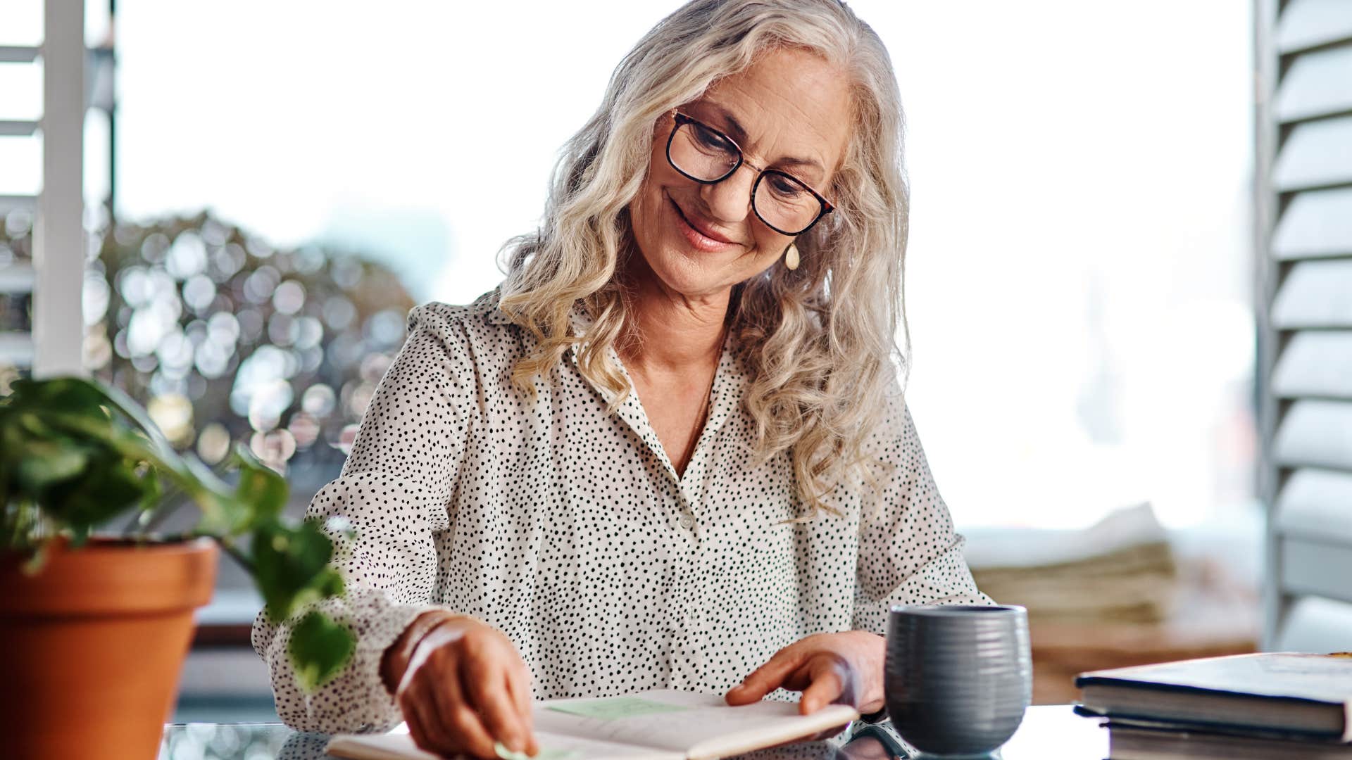 woman smiling and journaling at home