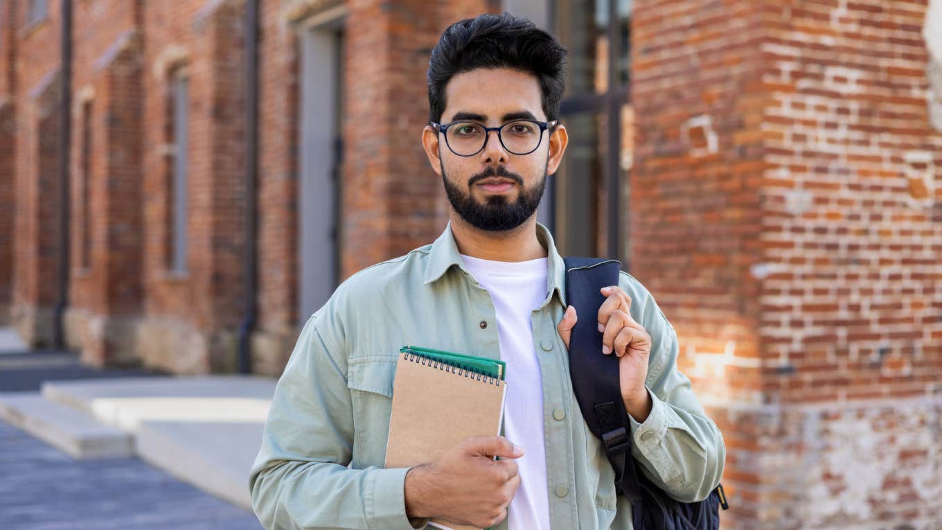 serious man standing in street holding notepad