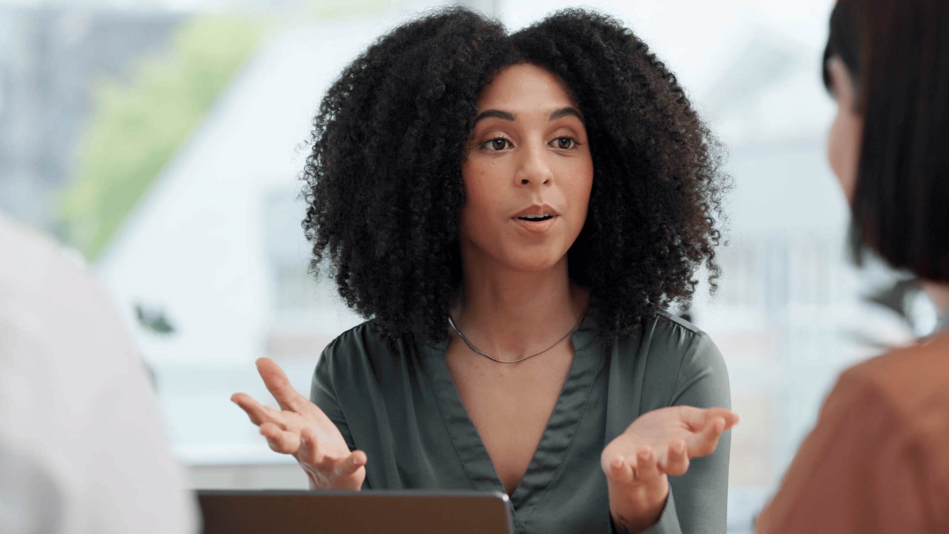 Woman saying It’s not me who needs to apologize to another woman across from a table