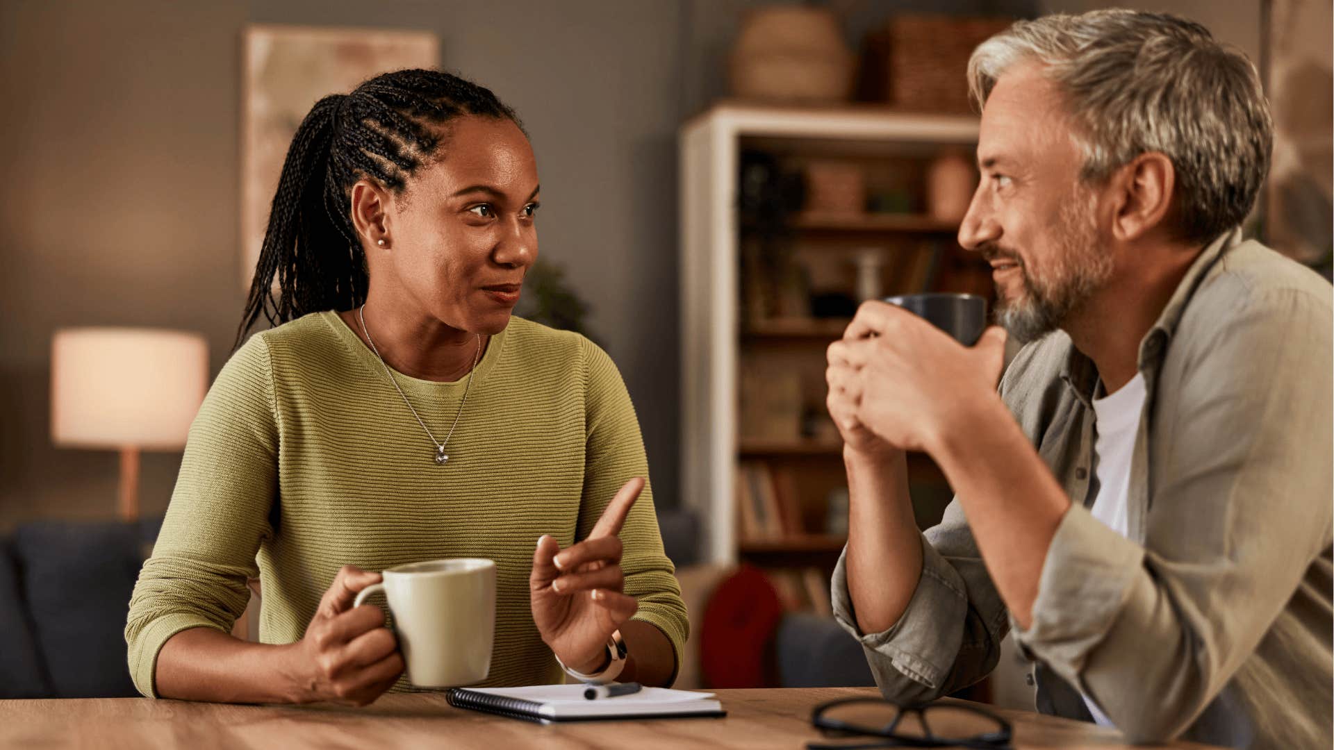 Woman pointing at her partner saying if I were you while drinking coffee