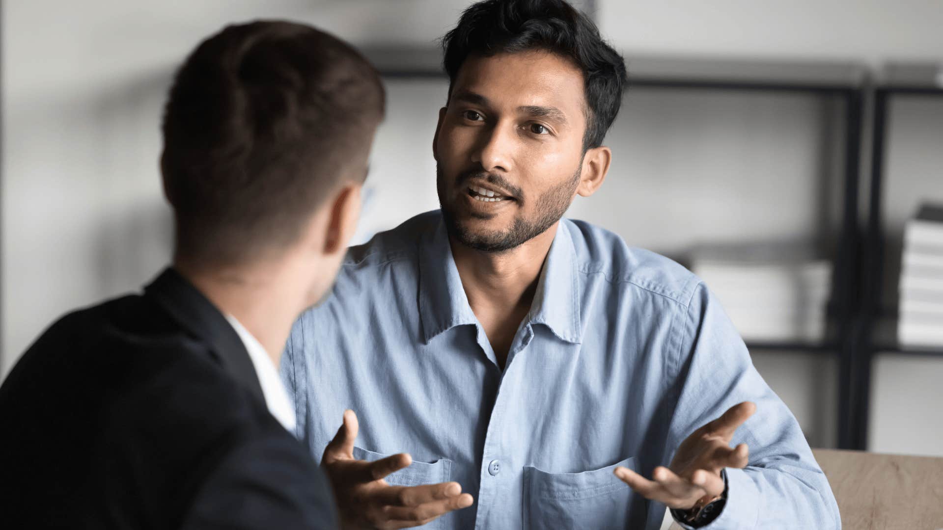 Professional man saying you sound ridiculous to a co-worker in an office