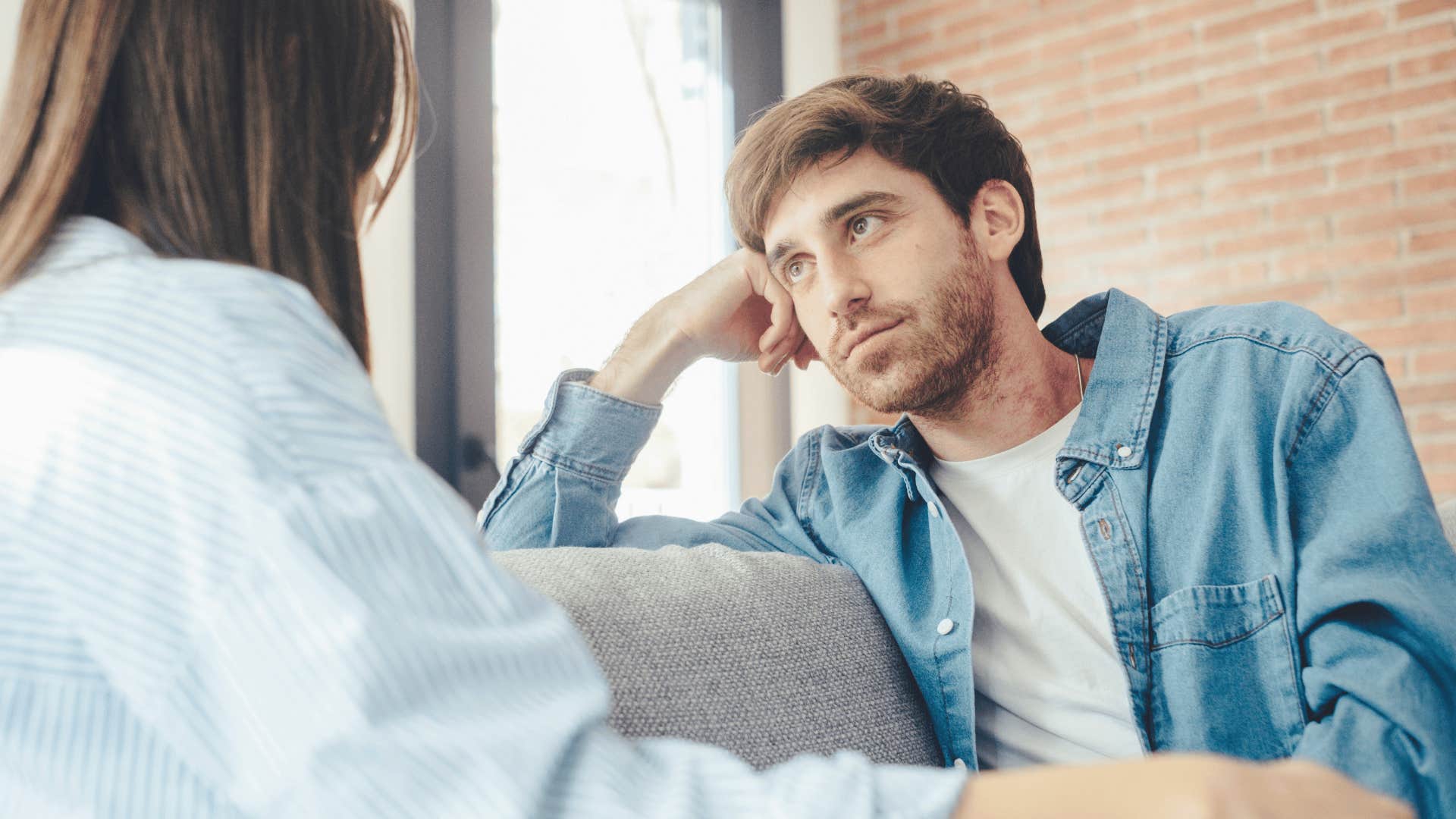 Serious man asking his partner do you always treat people this poorly on a couch