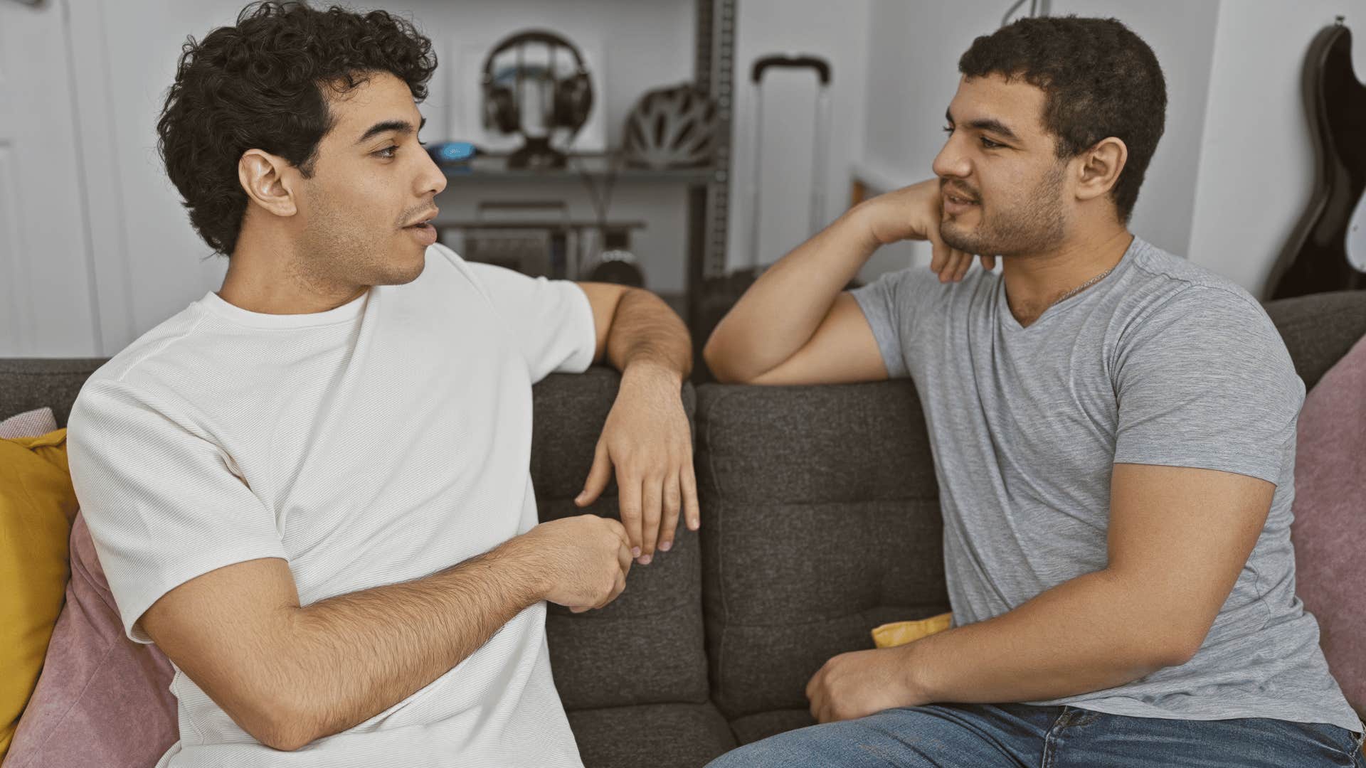 two men disagreeing sitting on couch