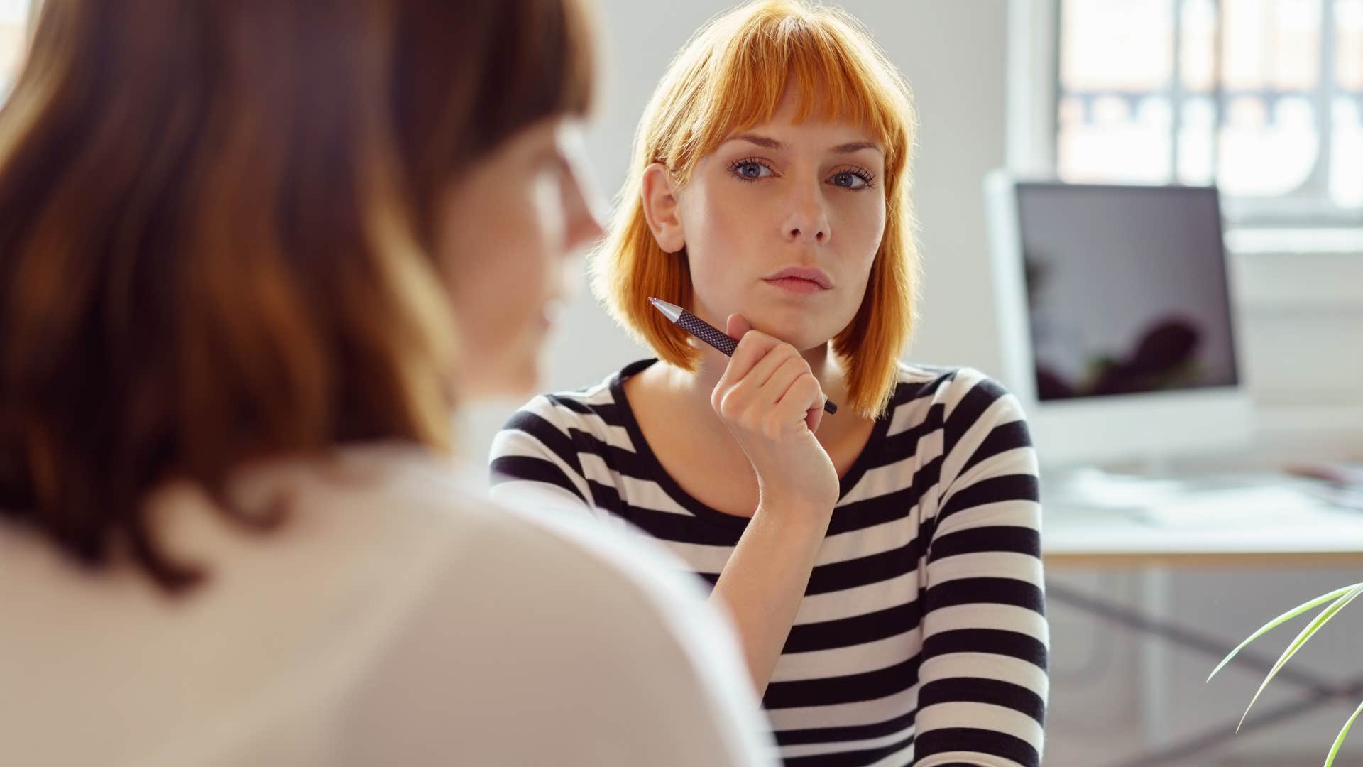 woman staring at co-worker saying she needs to get back to work