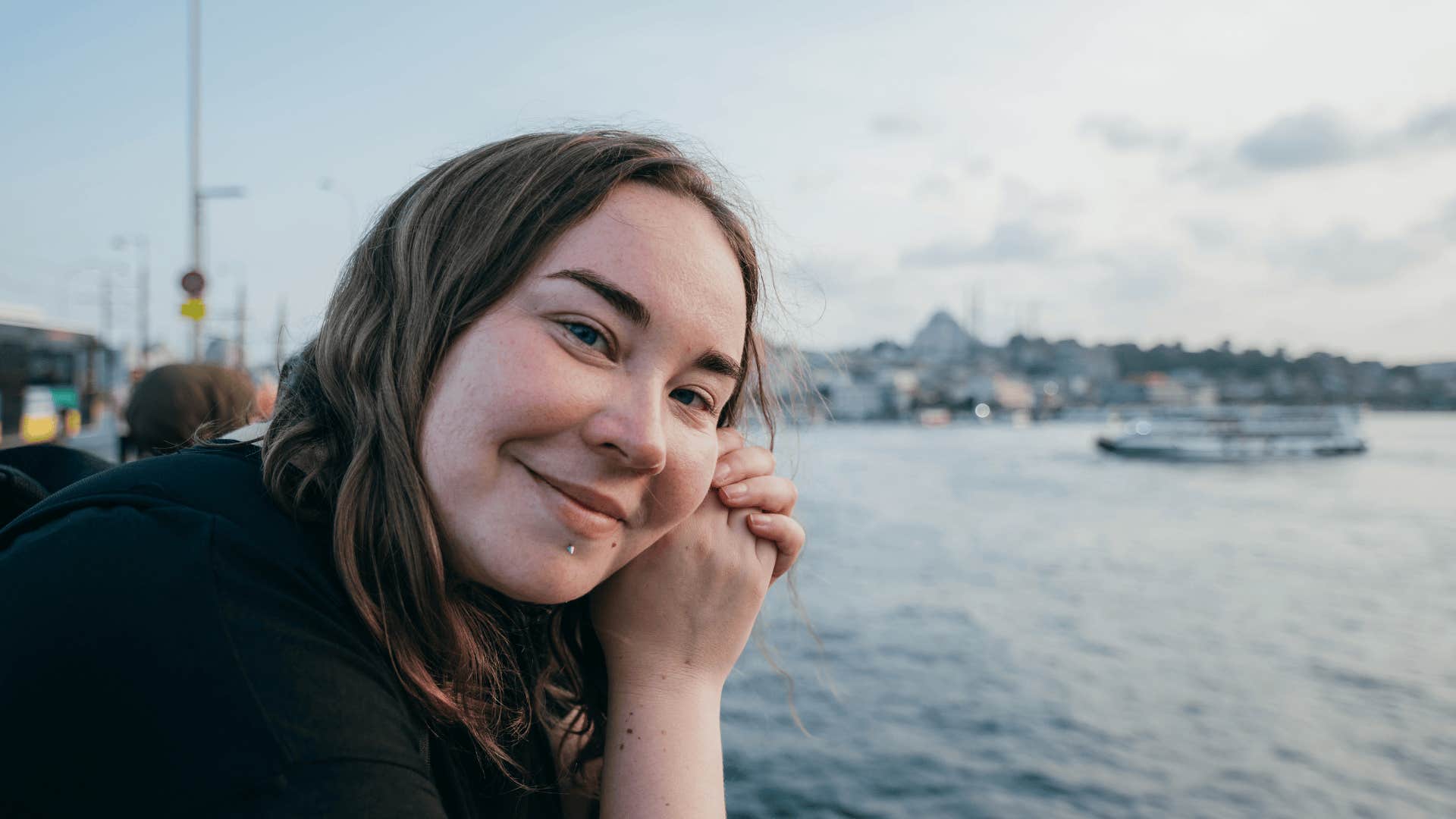 woman smiling by the water thinking I’m done convincing people of my worth