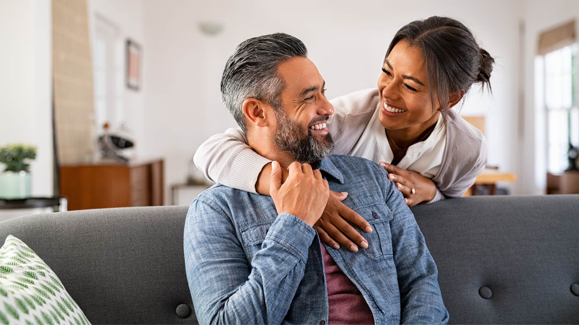 woman hugging partner from behind smiling offering support