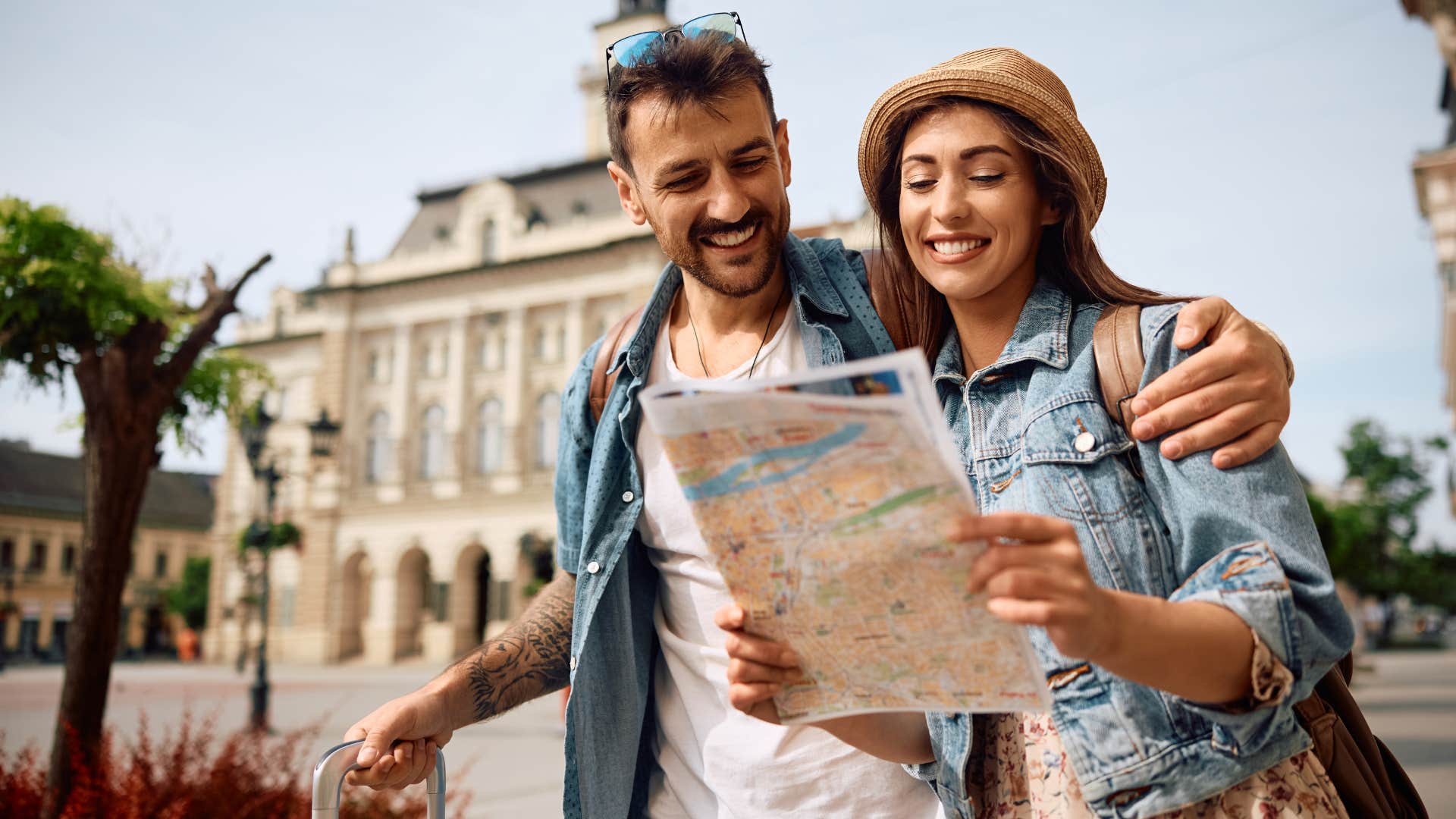 couple traveling abroad looking at map together