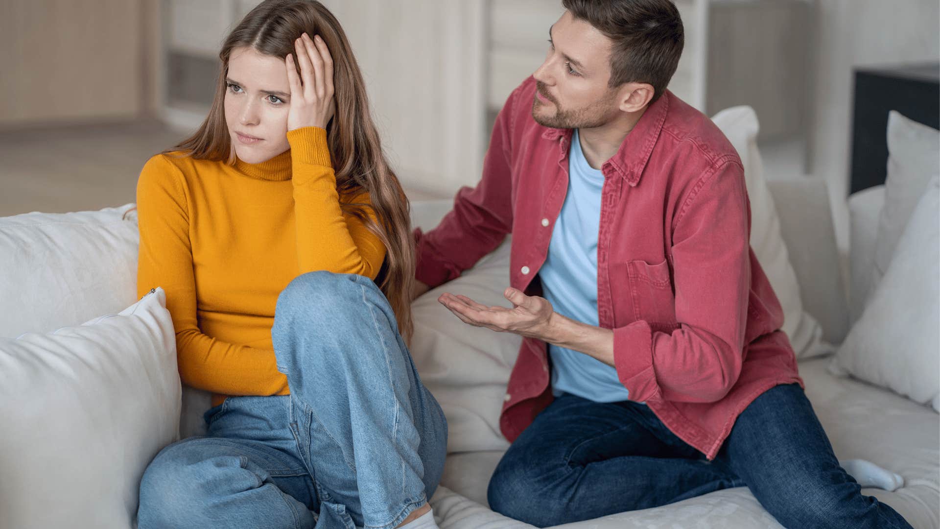A husband apologizes again to his wife on the couch.