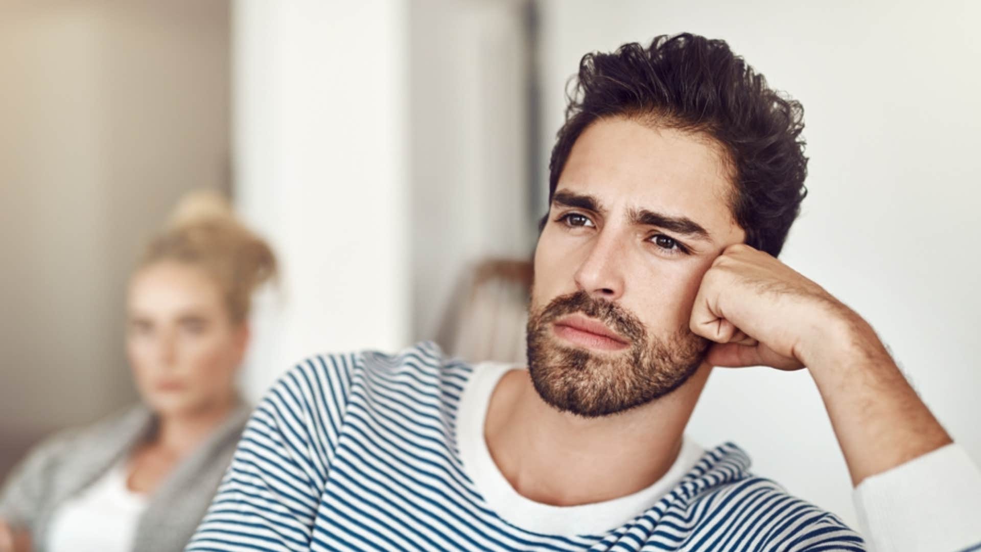 emotionally gone man turned away from girlfriend with a lot on his mind