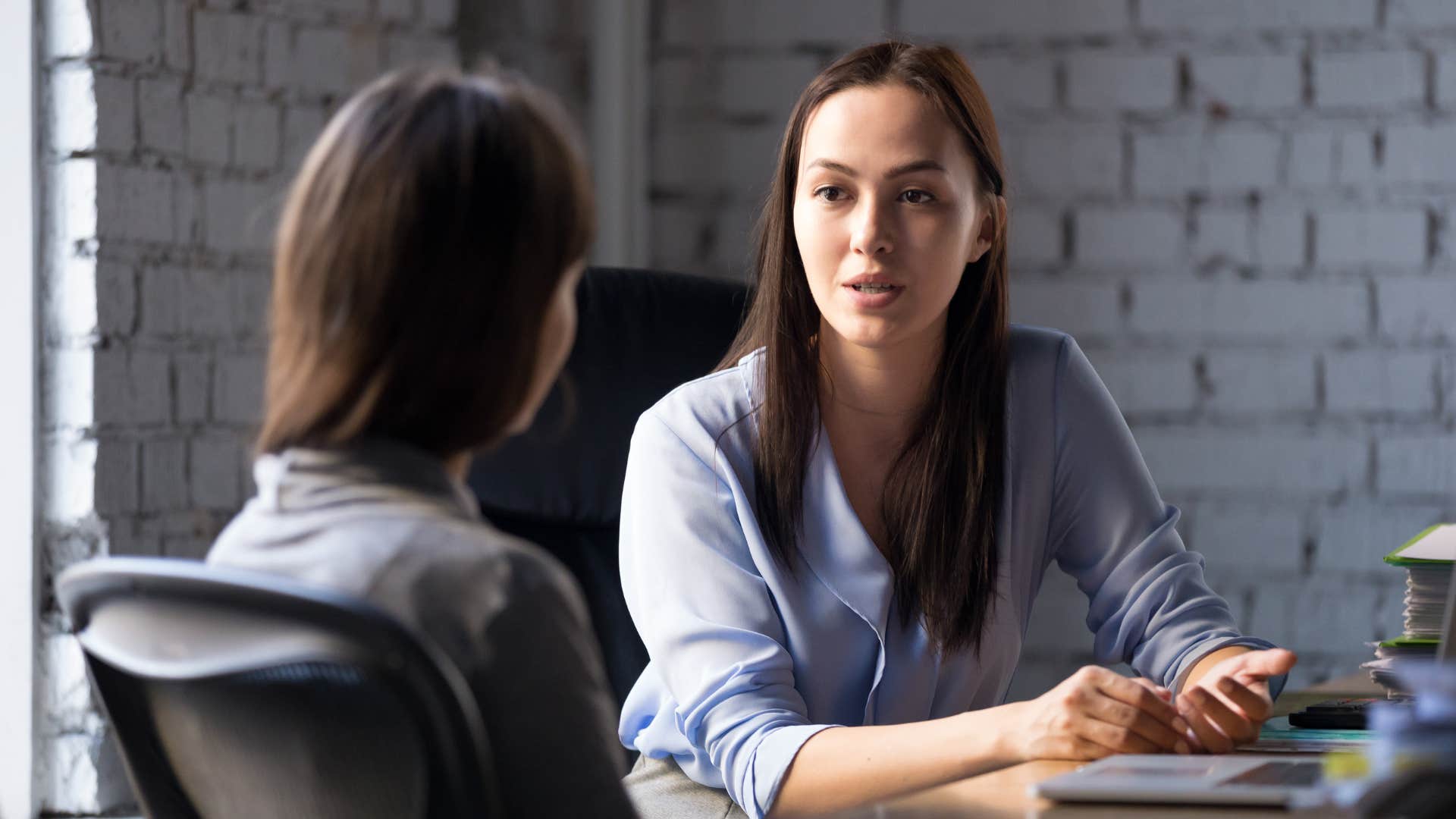 professional woman discussing technology in office with colleague