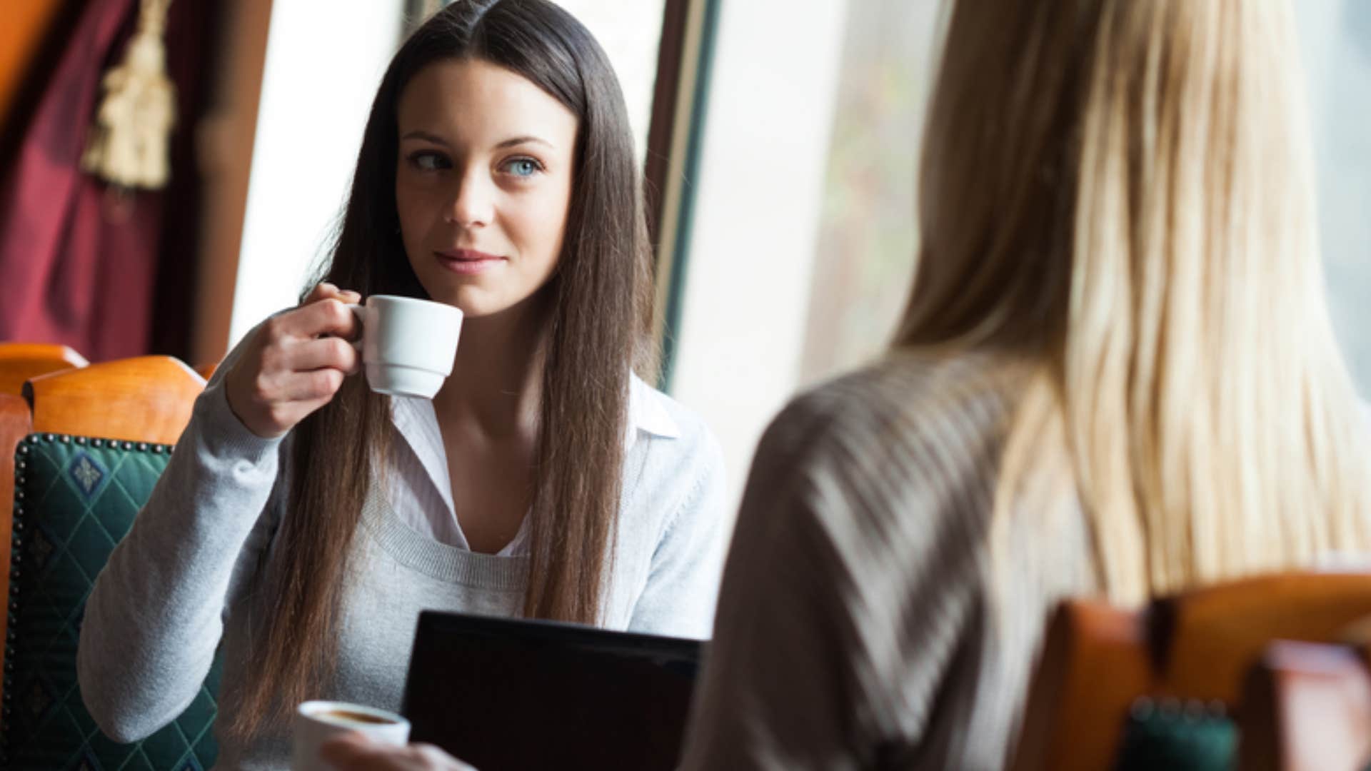 woman encouraging friend over coffee