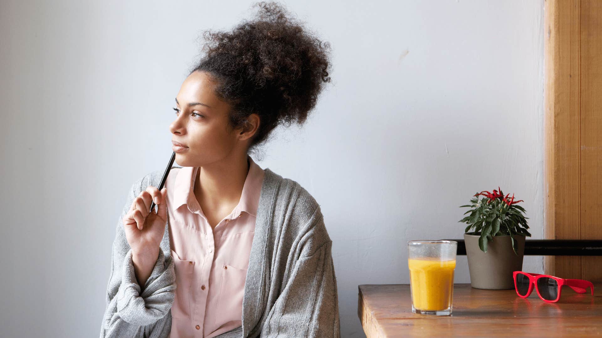 woman thinking while writing thank you note