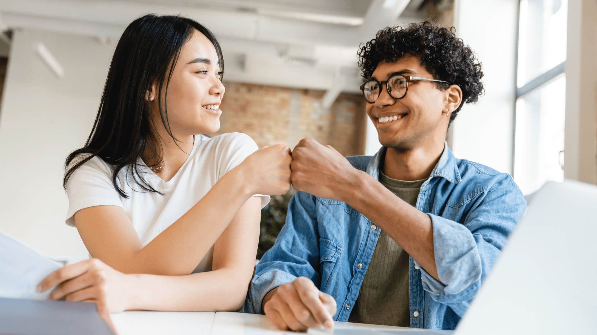 woman elevating friend with fist bump