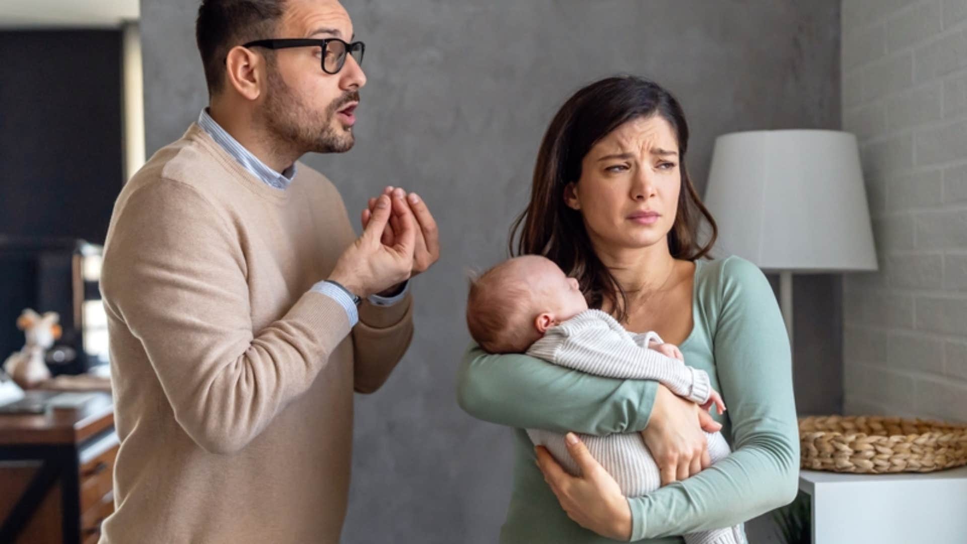 selfish husband being rude to wife holding their baby