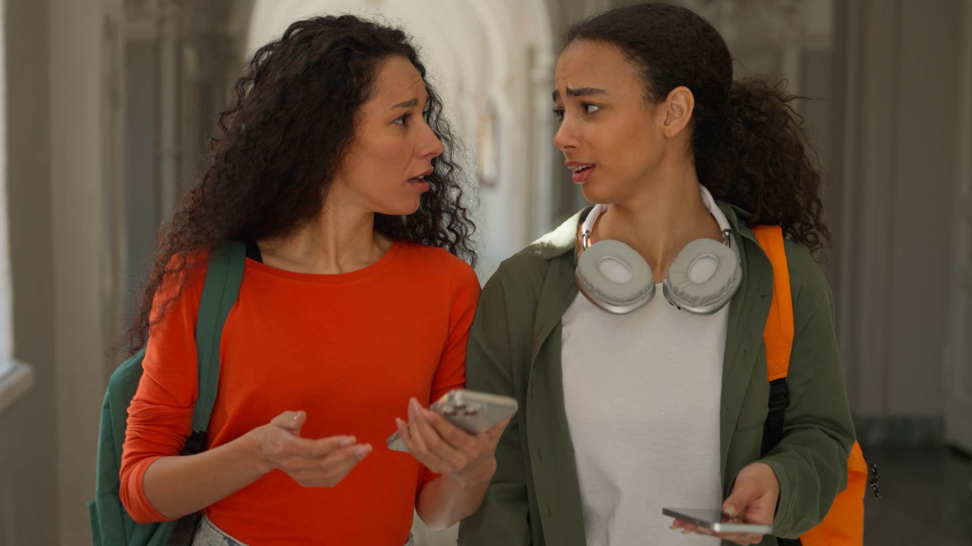 Woman saying "no offense, but" to her friend while walking.