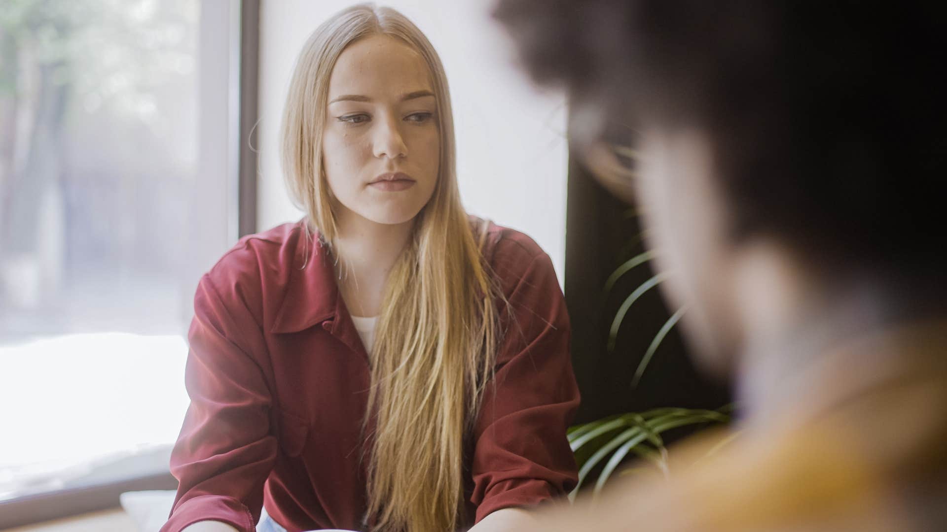 Upset woman saying "I'm just being honest" to her partner.