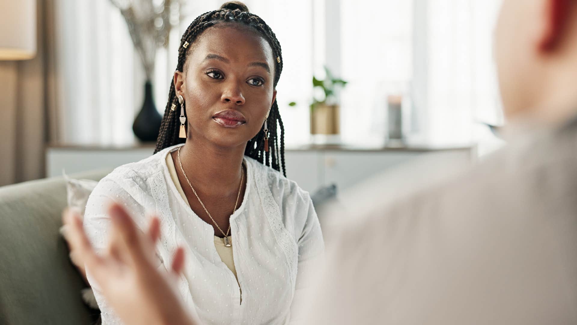 Woman thinking "that's not fair" talking to a co-worker.
