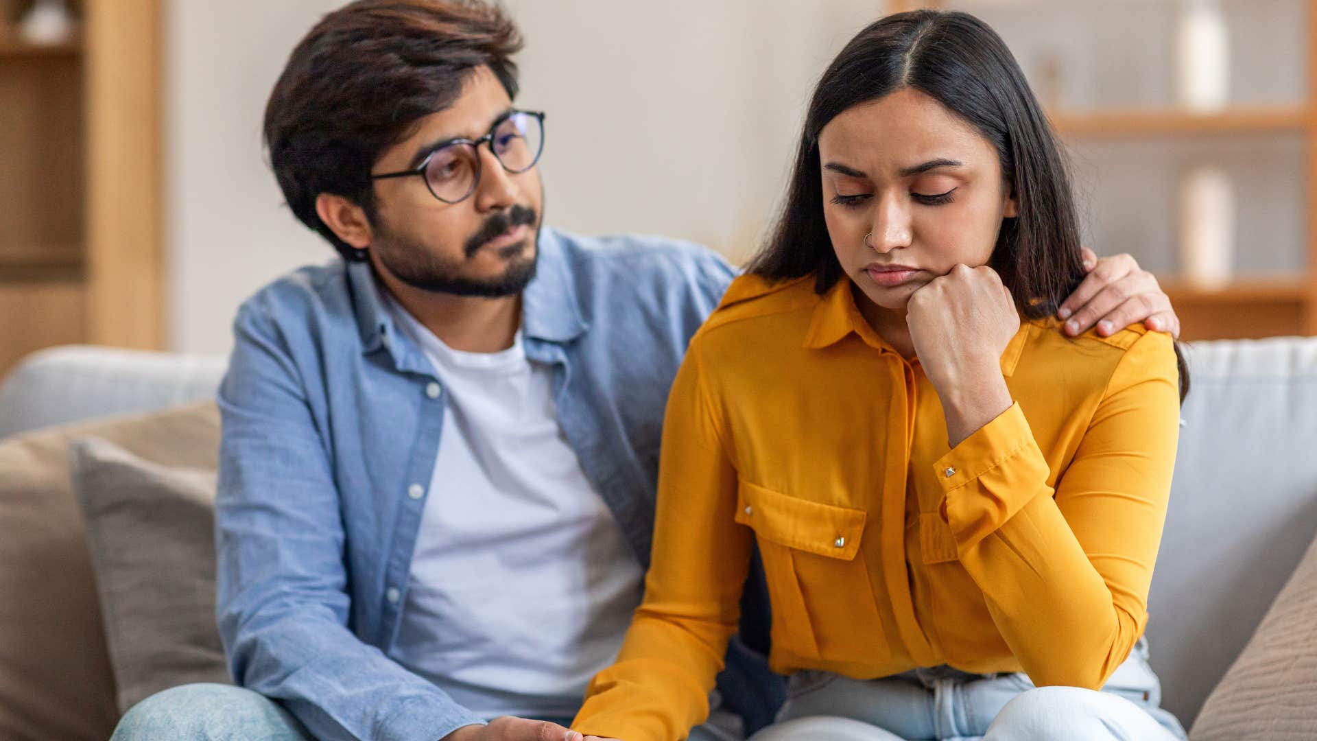 Upset woman turned away from her husband after saying "whatever."