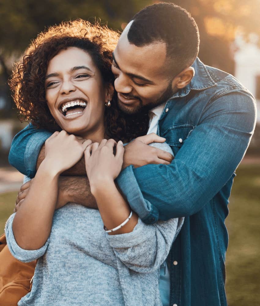 Irresistible man is doing his best to hug happy woman 