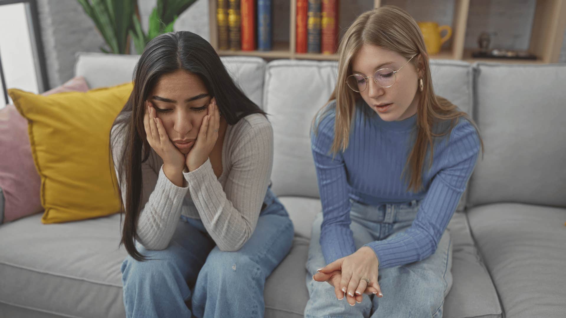 upset friends sitting on couch with one judging the other's actions