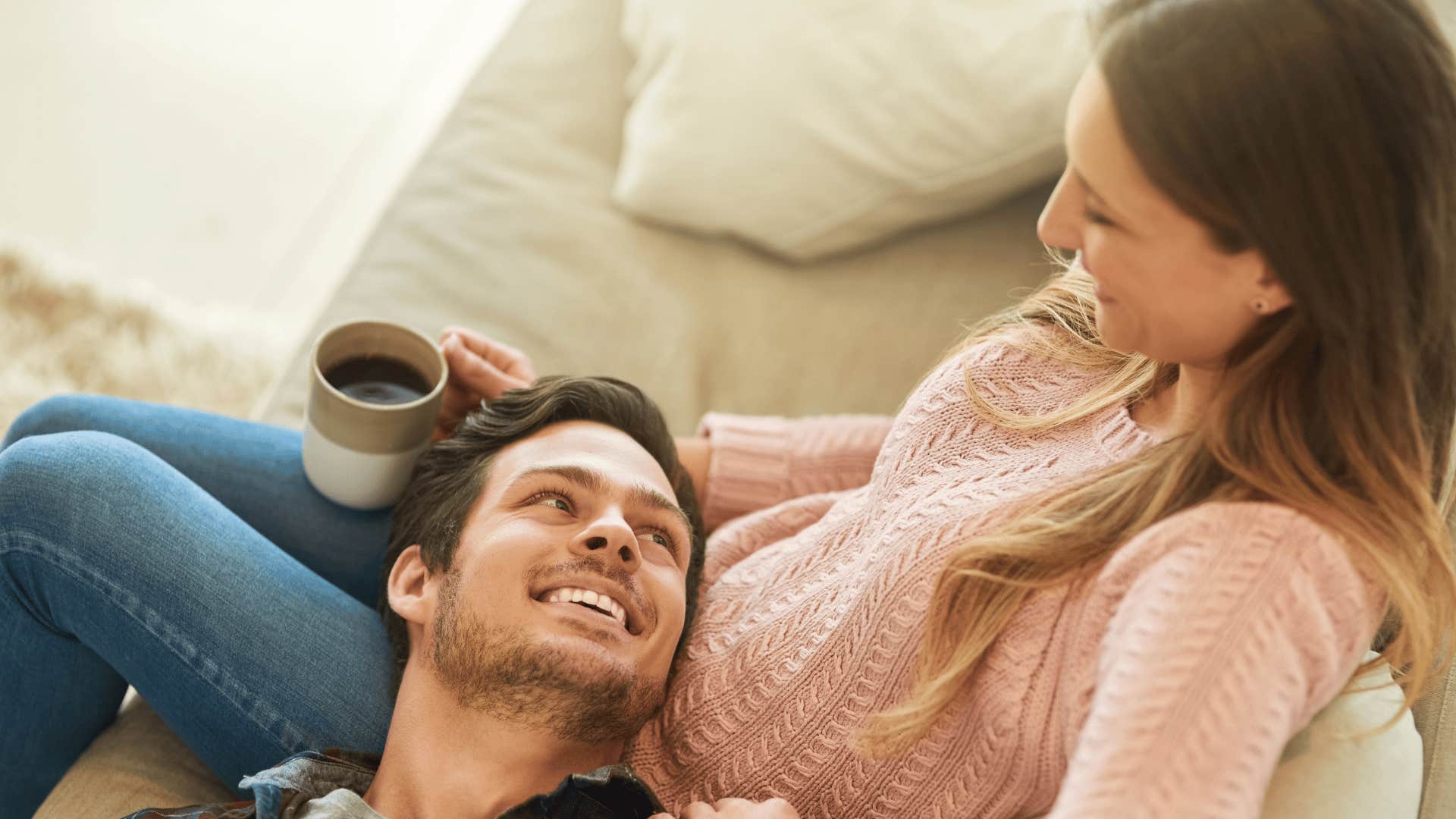 smiling man who is a darn good husband with his head in wife's lap