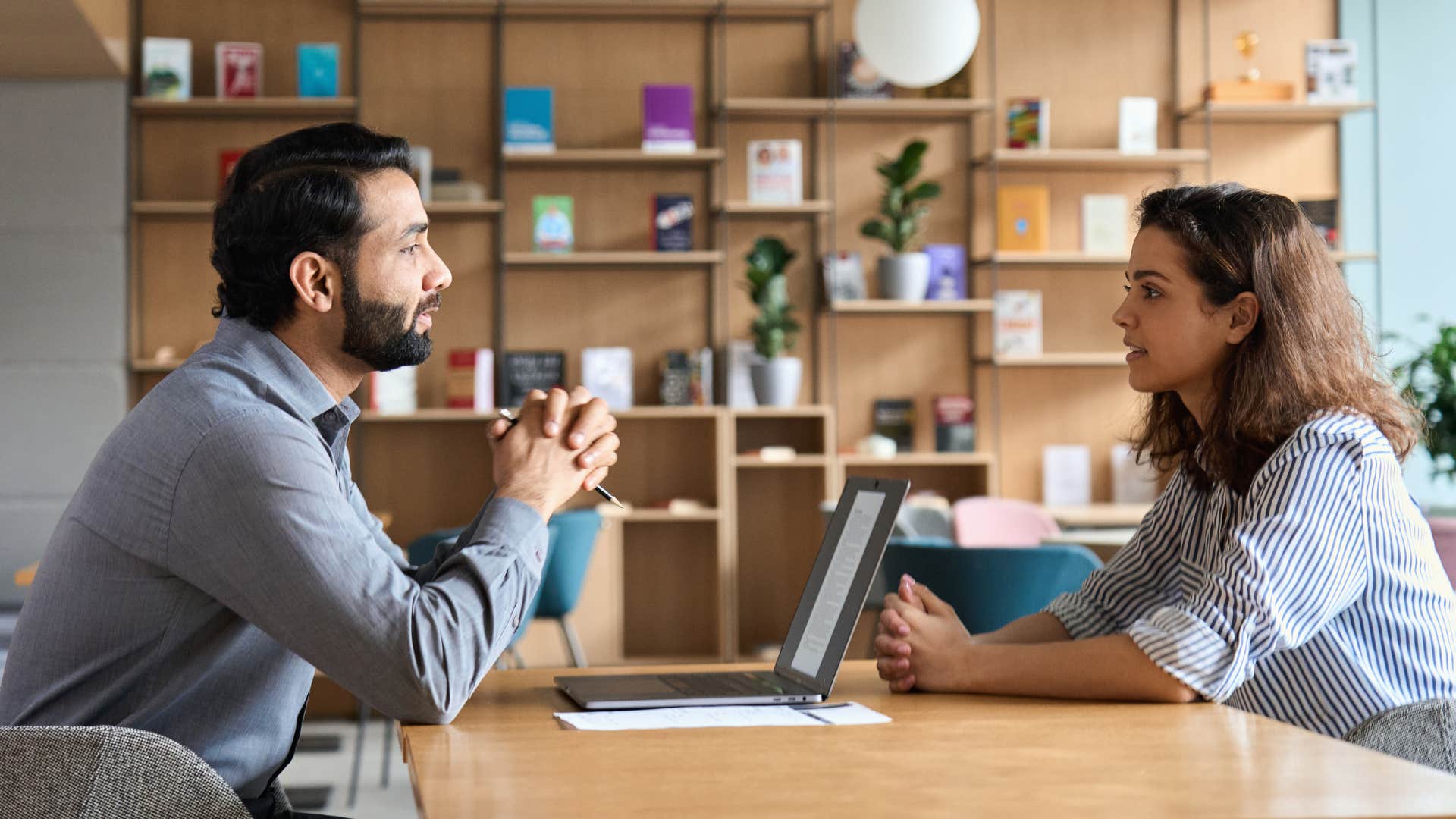 man asking woman what's one thing she's working on to better herself as they sit across from one another and he clasps his hand