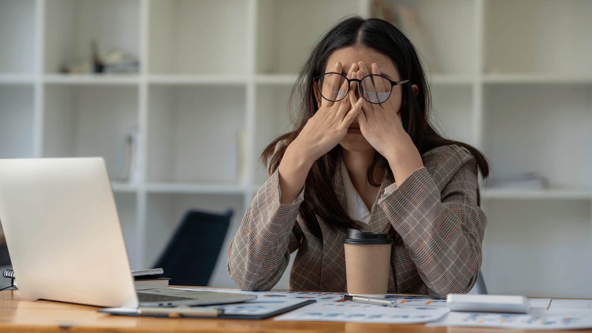 woman with glasses looks frustrated as she struggles to balance her career and being a mother
