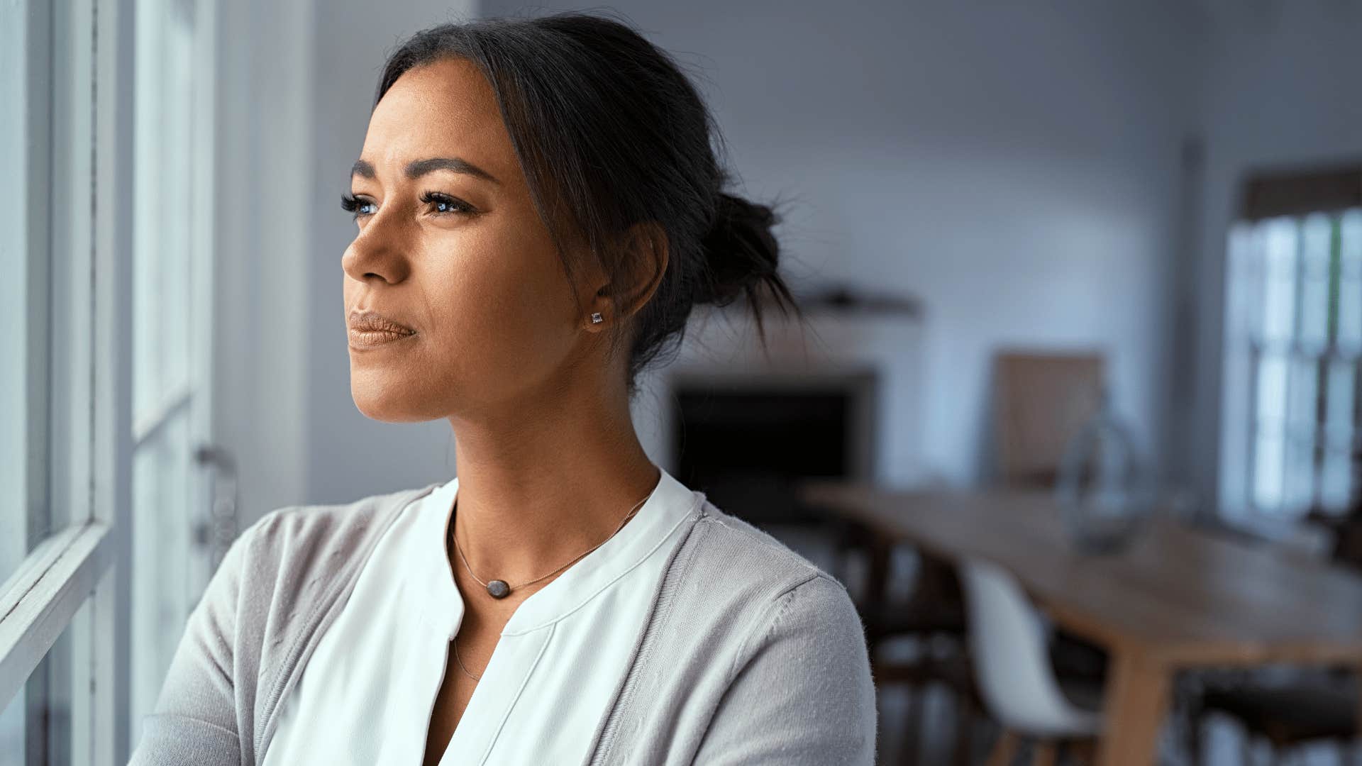 woman feeling guilt while staring out the window 
