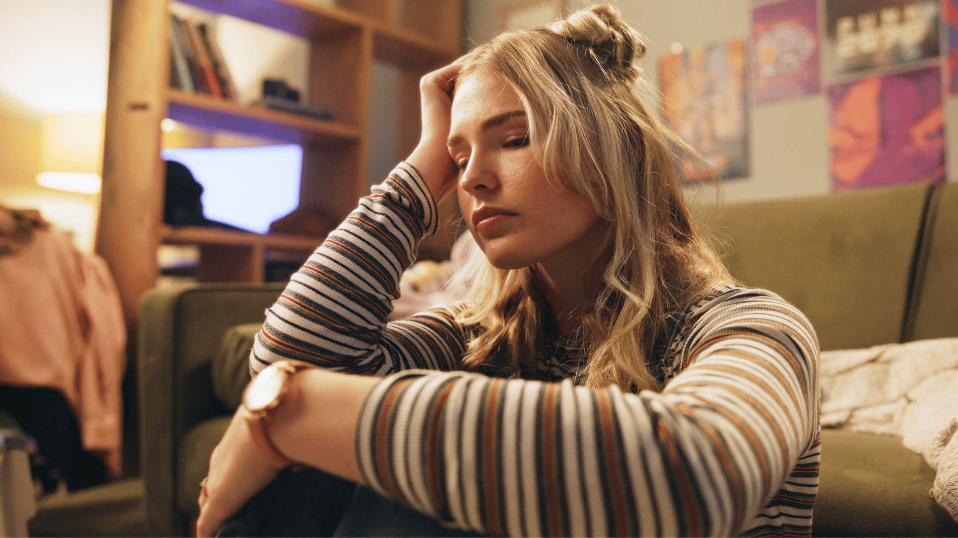 woman struggling with self-care as she sits down with head in hands looking defeated