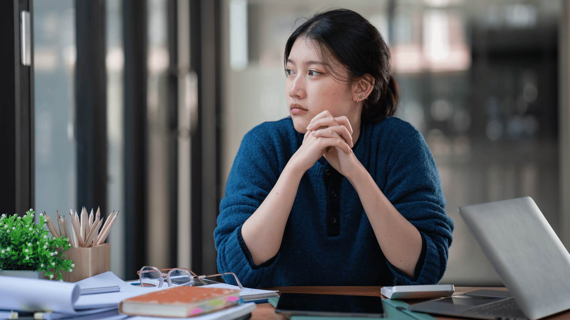woman feeling resentment as she stares off into space while she should be working