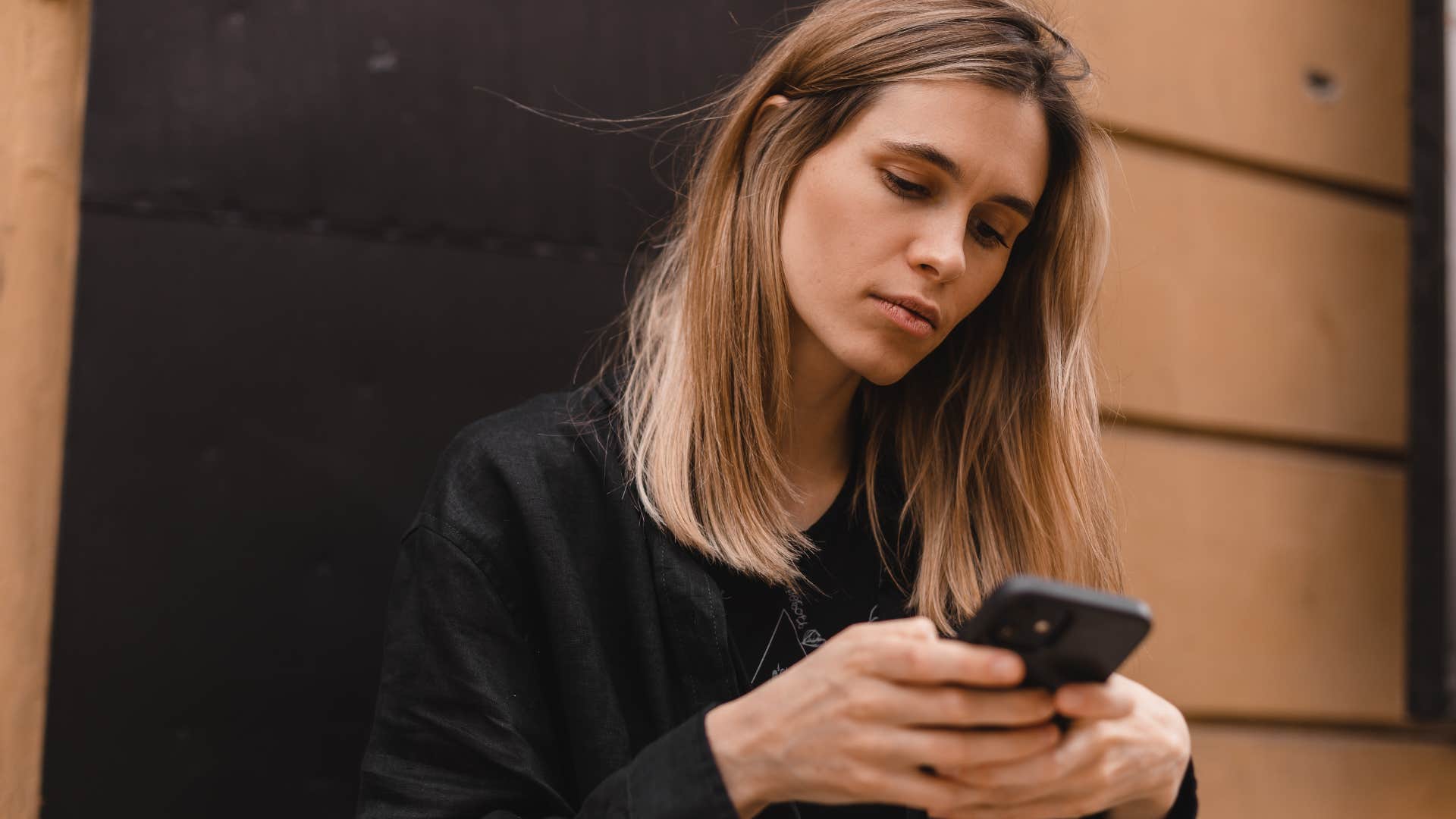 woman unfollowing friend's social media on her phone