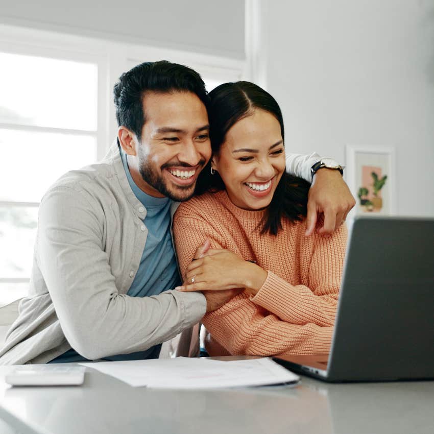 man who is unforgettable to women hugging his partner in front of laptop