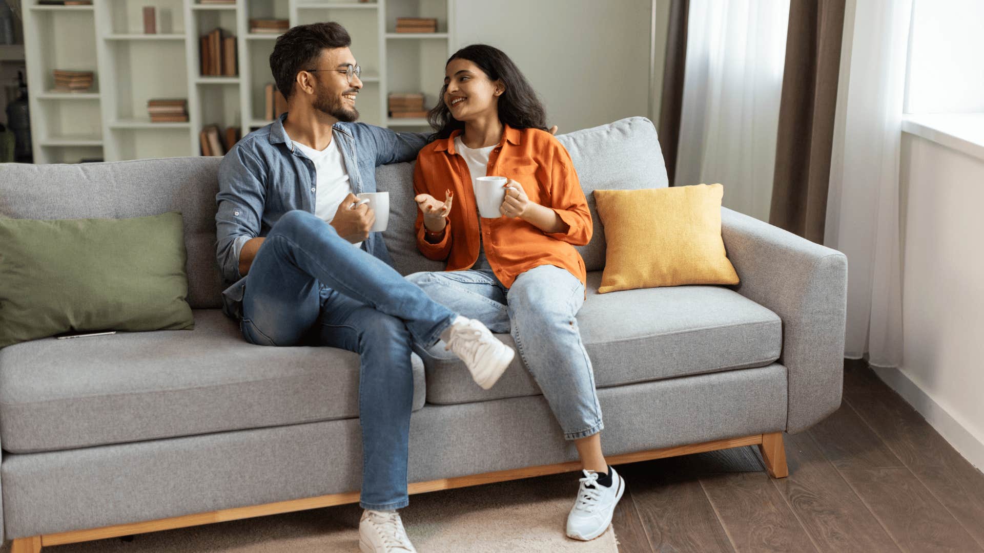 smiling man who is unforgettable next to wife on couch