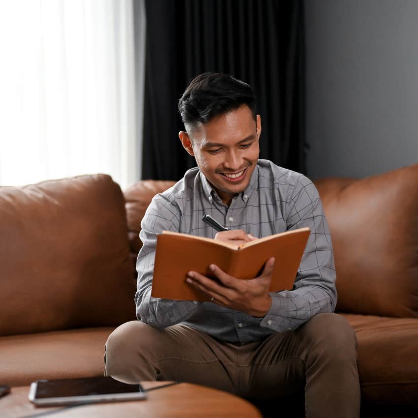 smiling man who stands out to women writing in notebook